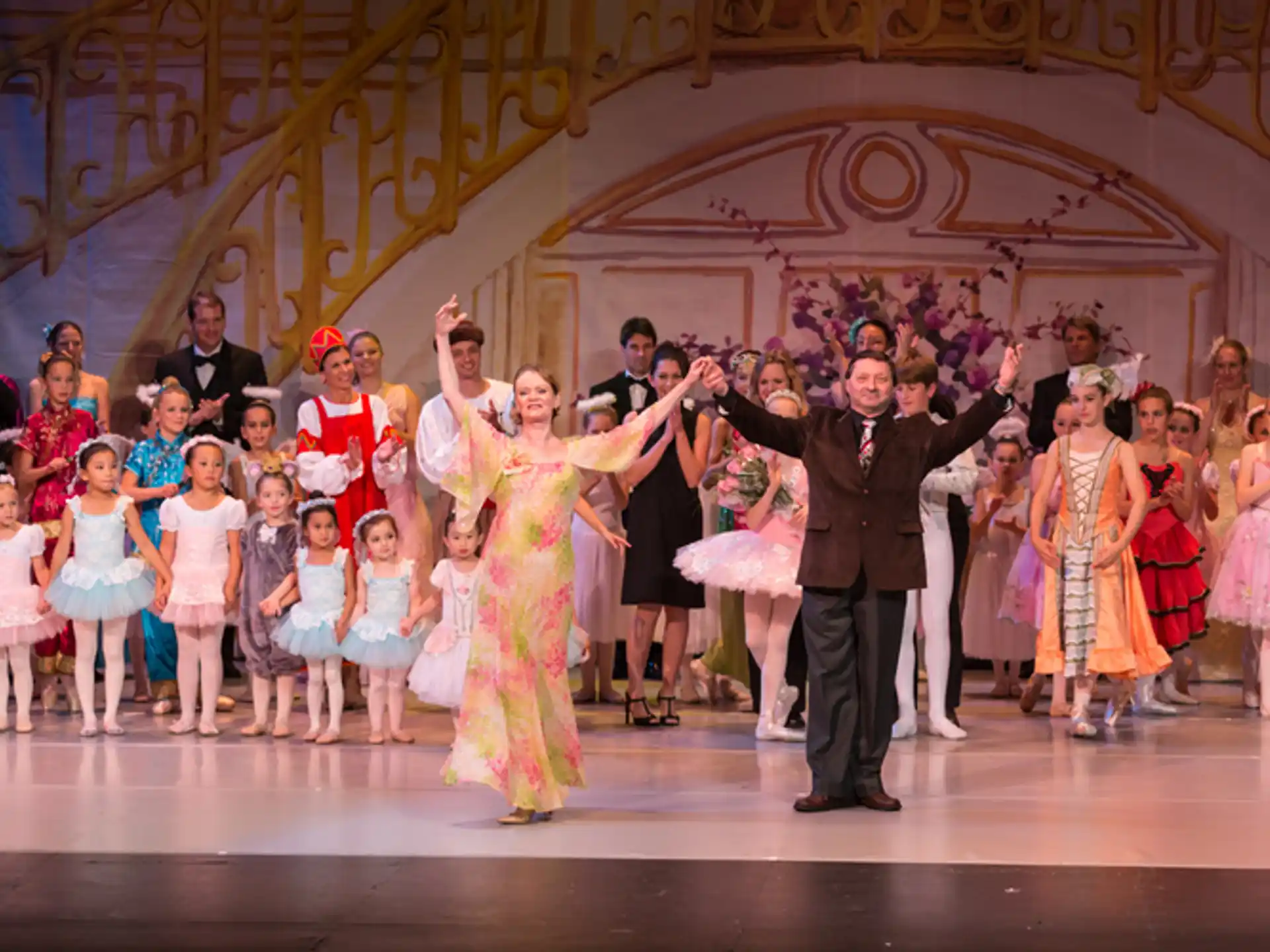 a man and woman dancing on a stage with a group of people