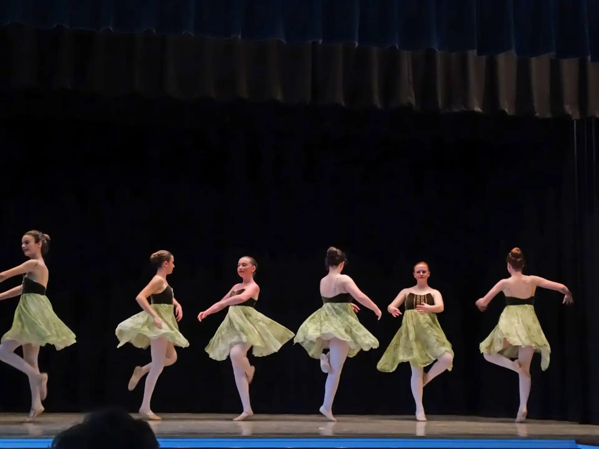 a group of girls dancing on a stage
