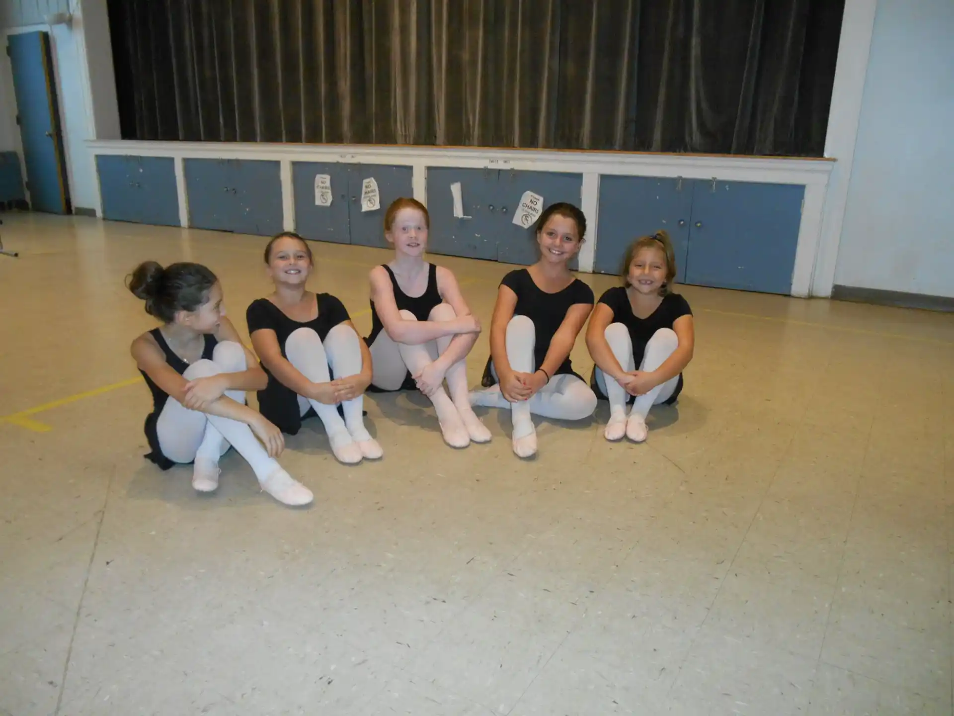 a group of girls sitting on the ground