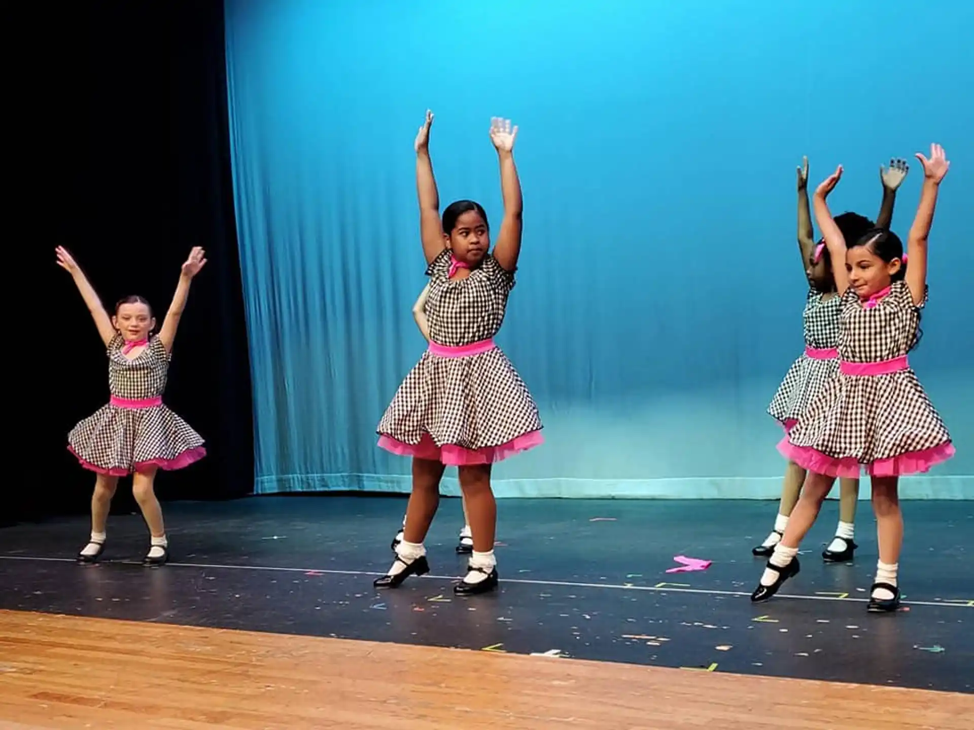 a group of girls dancing on a stage