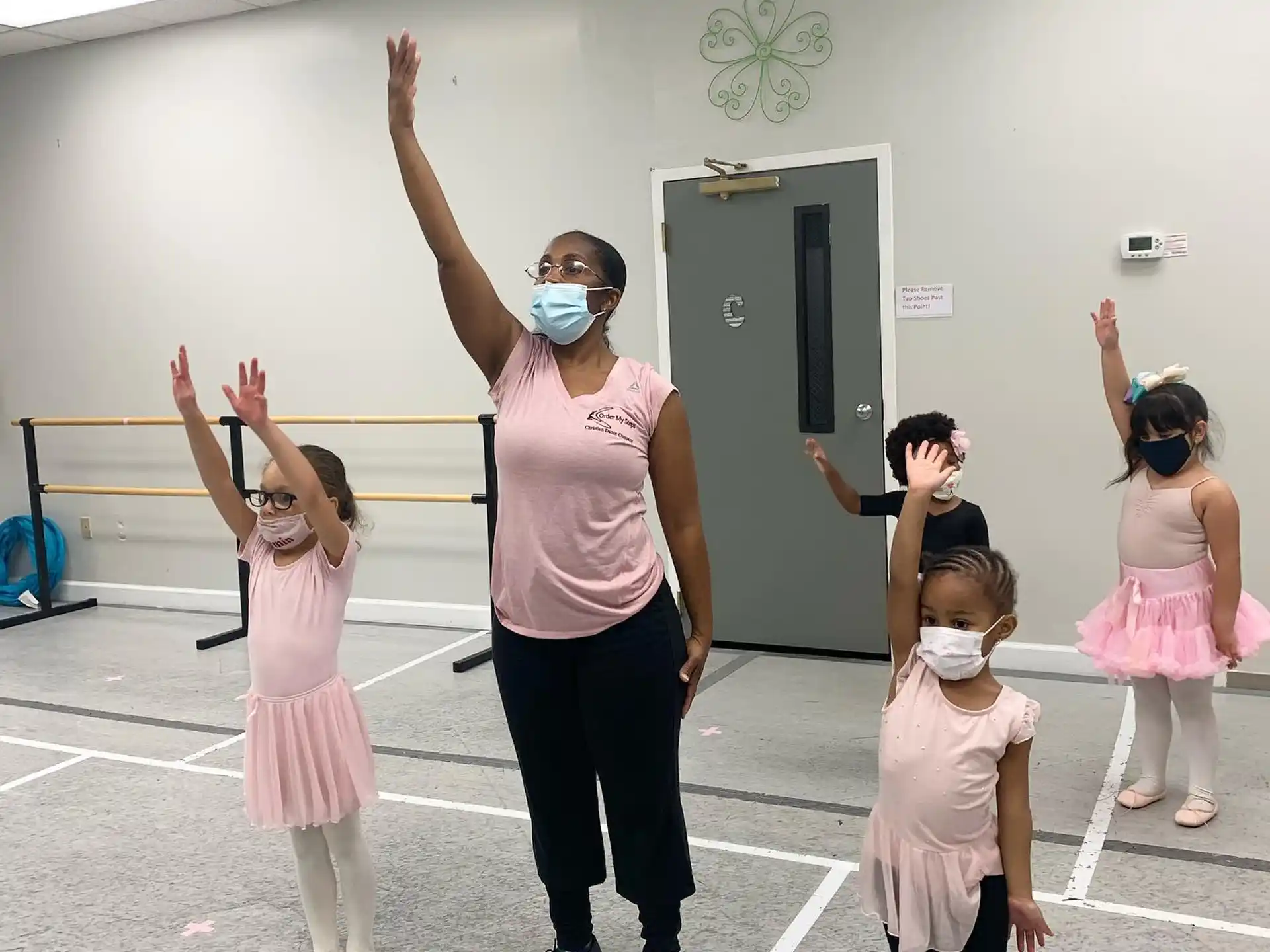a person and a group of children dancing in a gym