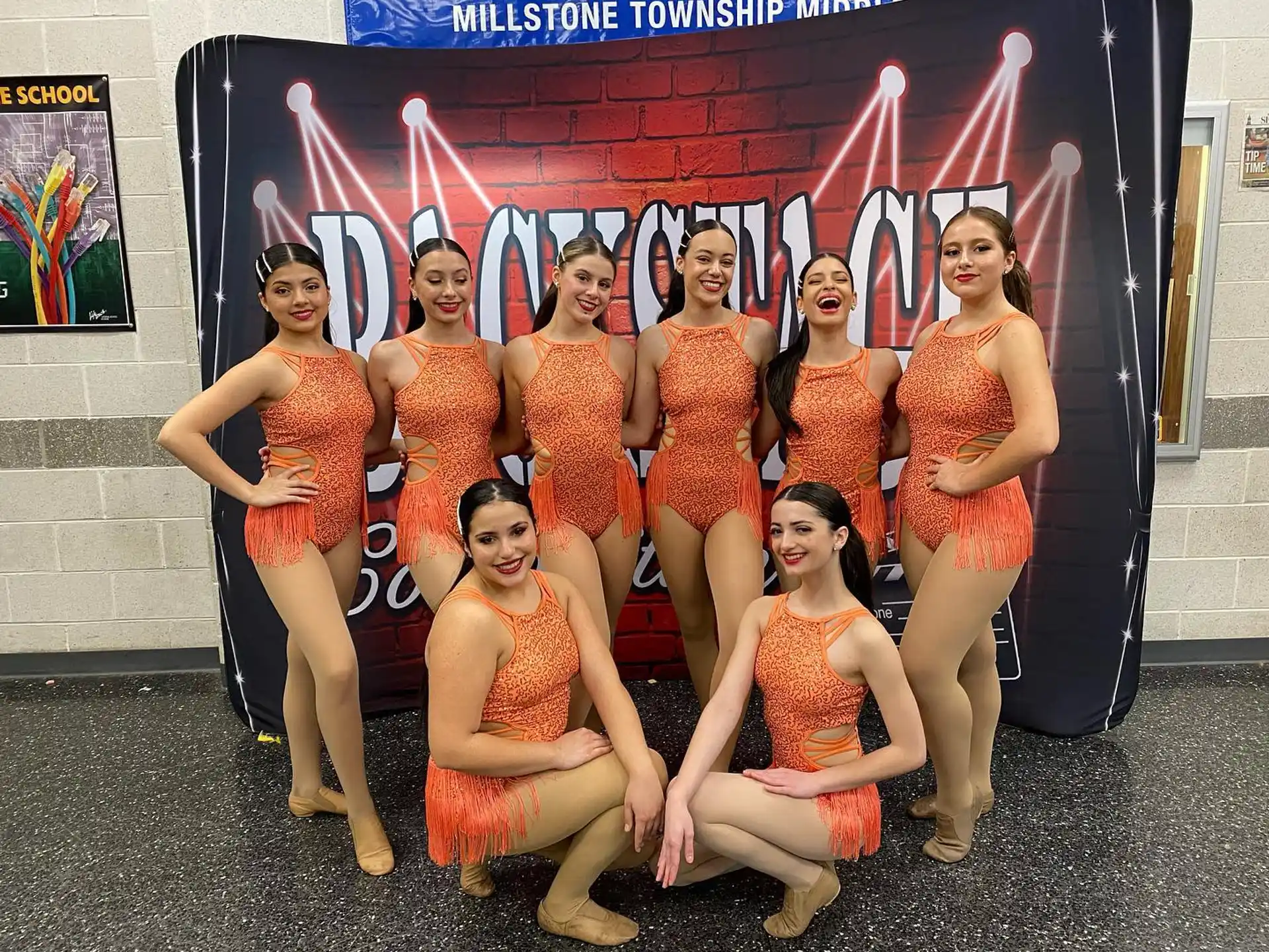 a group of women in orange dresses