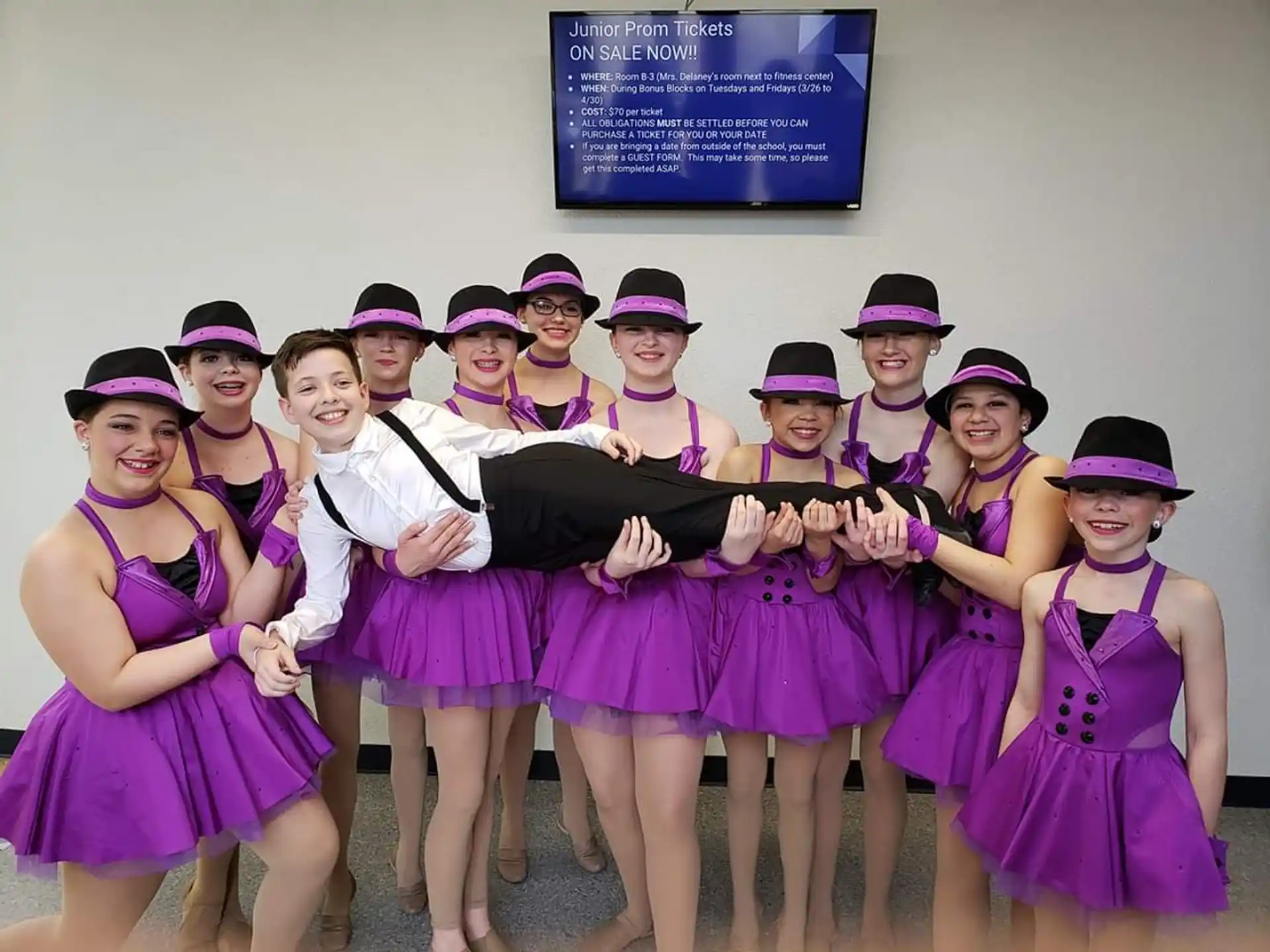 a group of people wearing purple and black hats posing for the camera