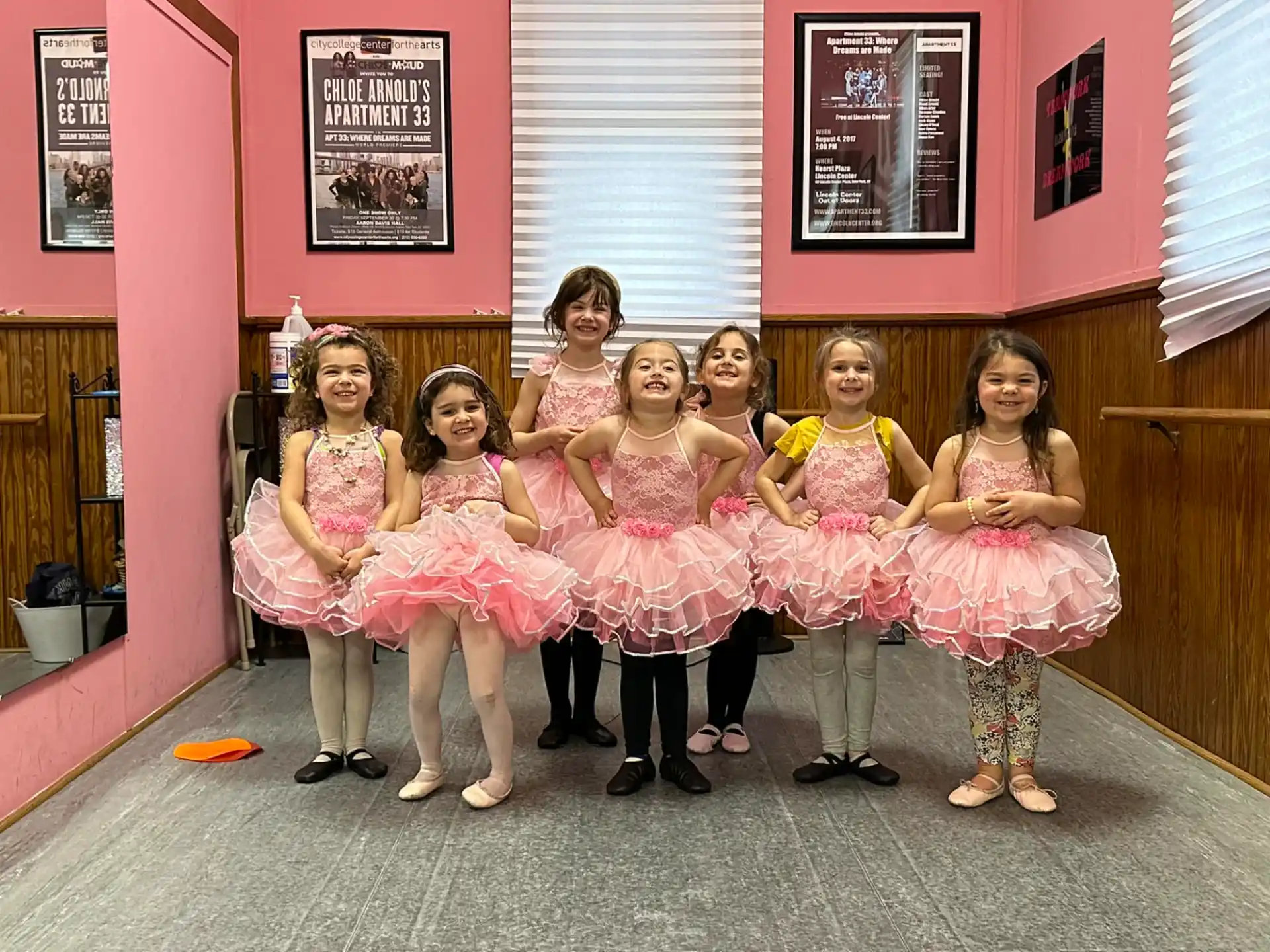 a group of girls in dresses posing for a photo