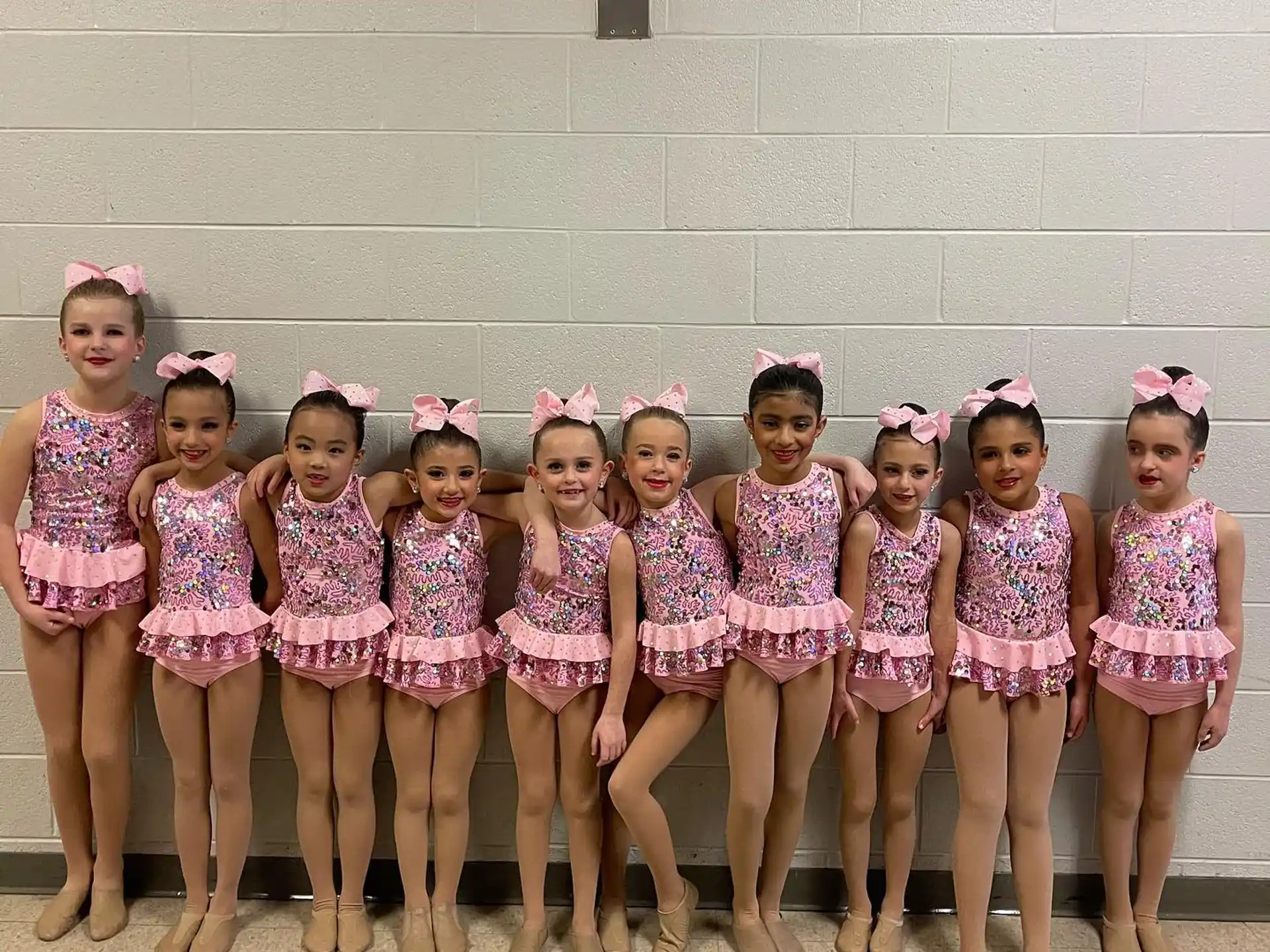 a group of girls in pink and white dresses
