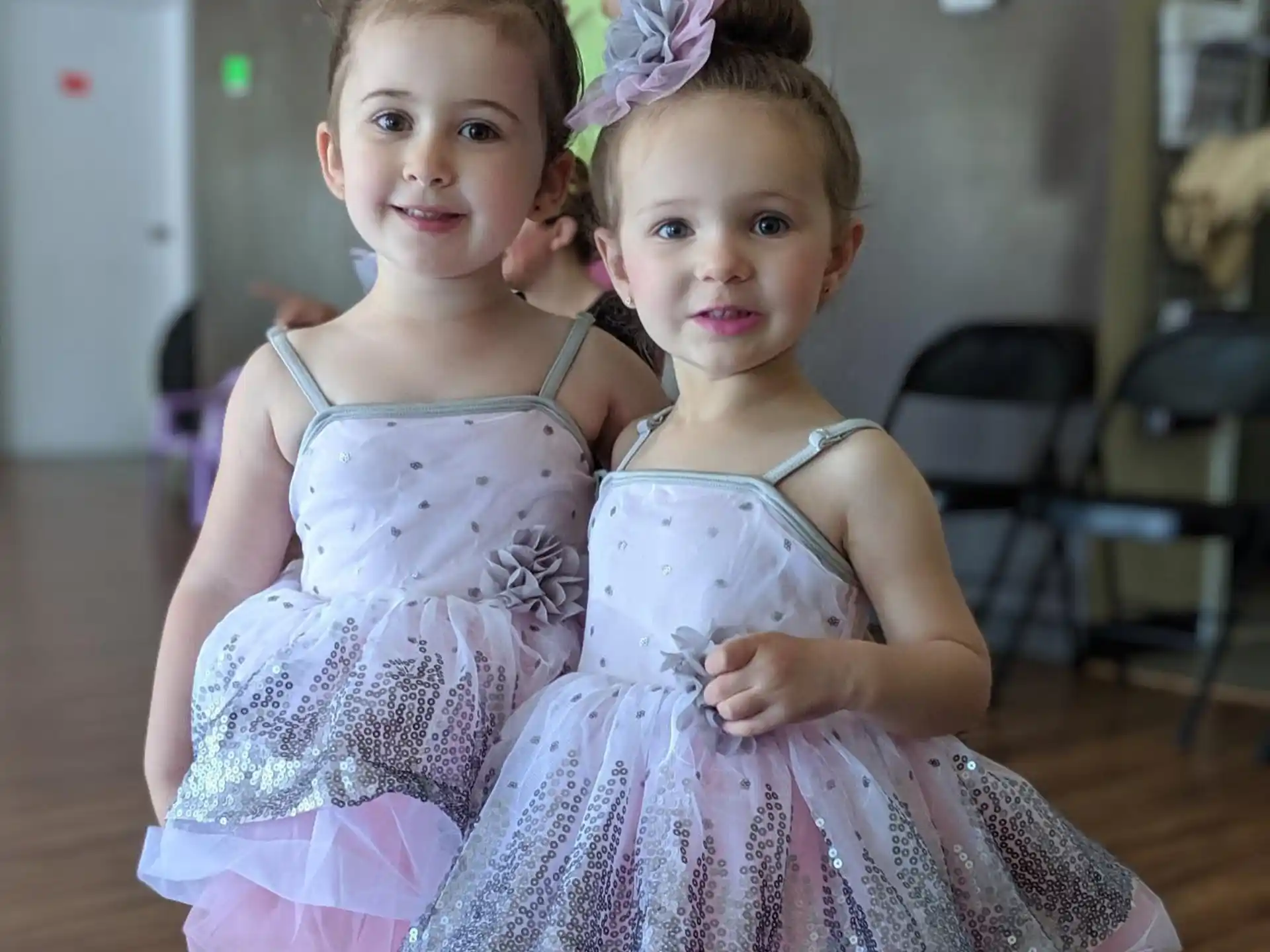 two girls wearing dresses and posing for a picture