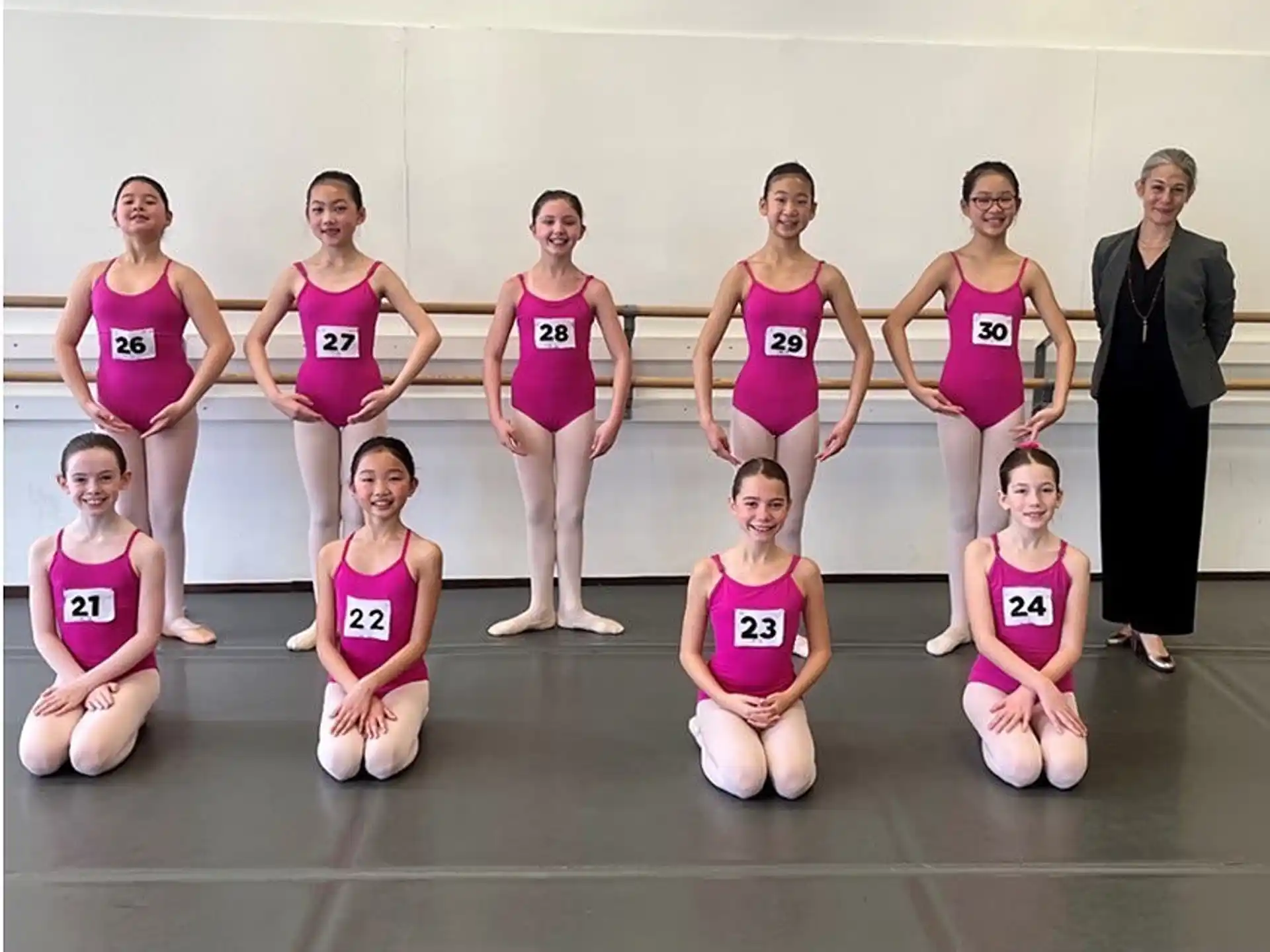 a group of women in pink leotards posing for a photo