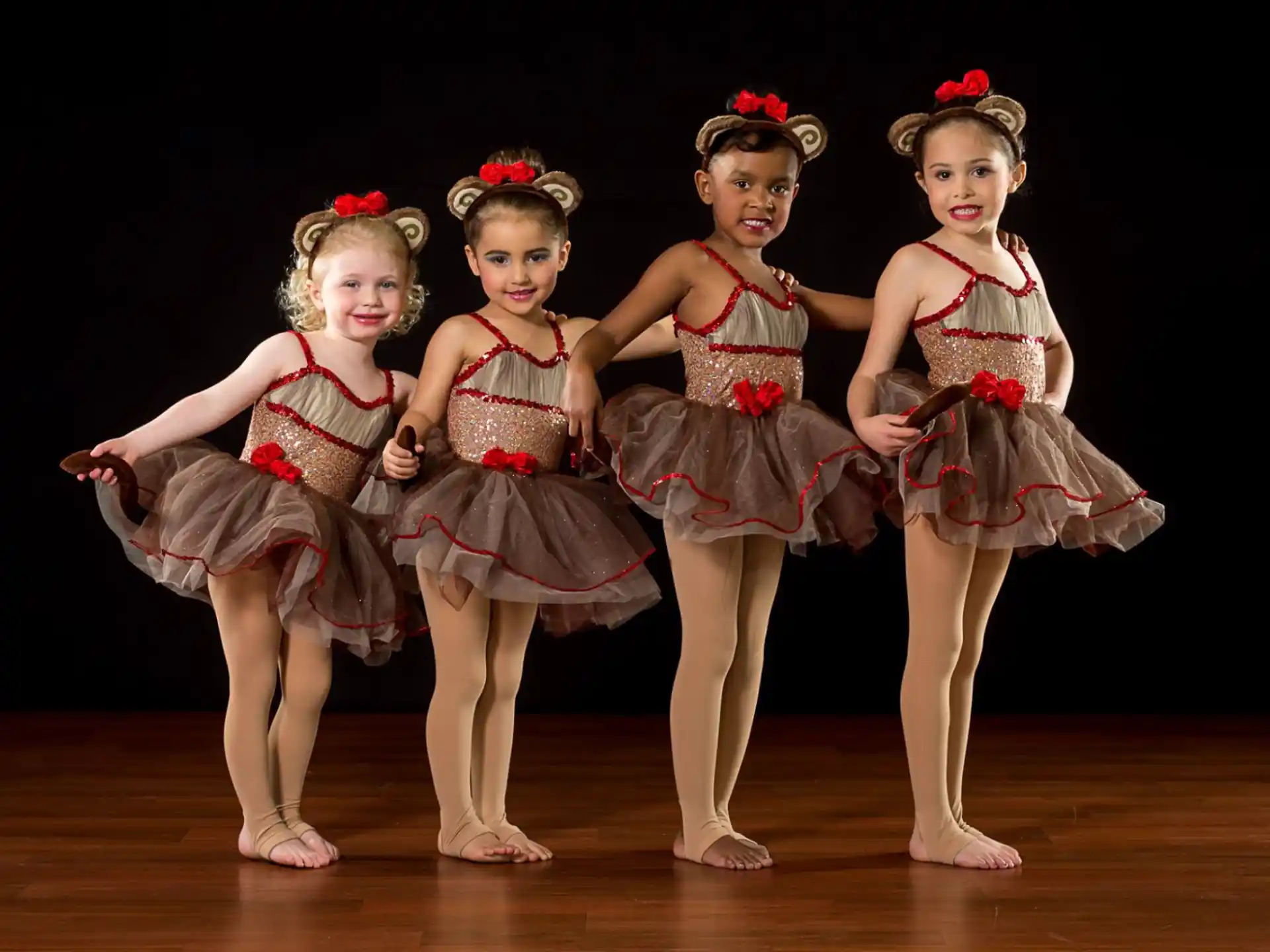 a group of girls in dresses and skirts on a stage