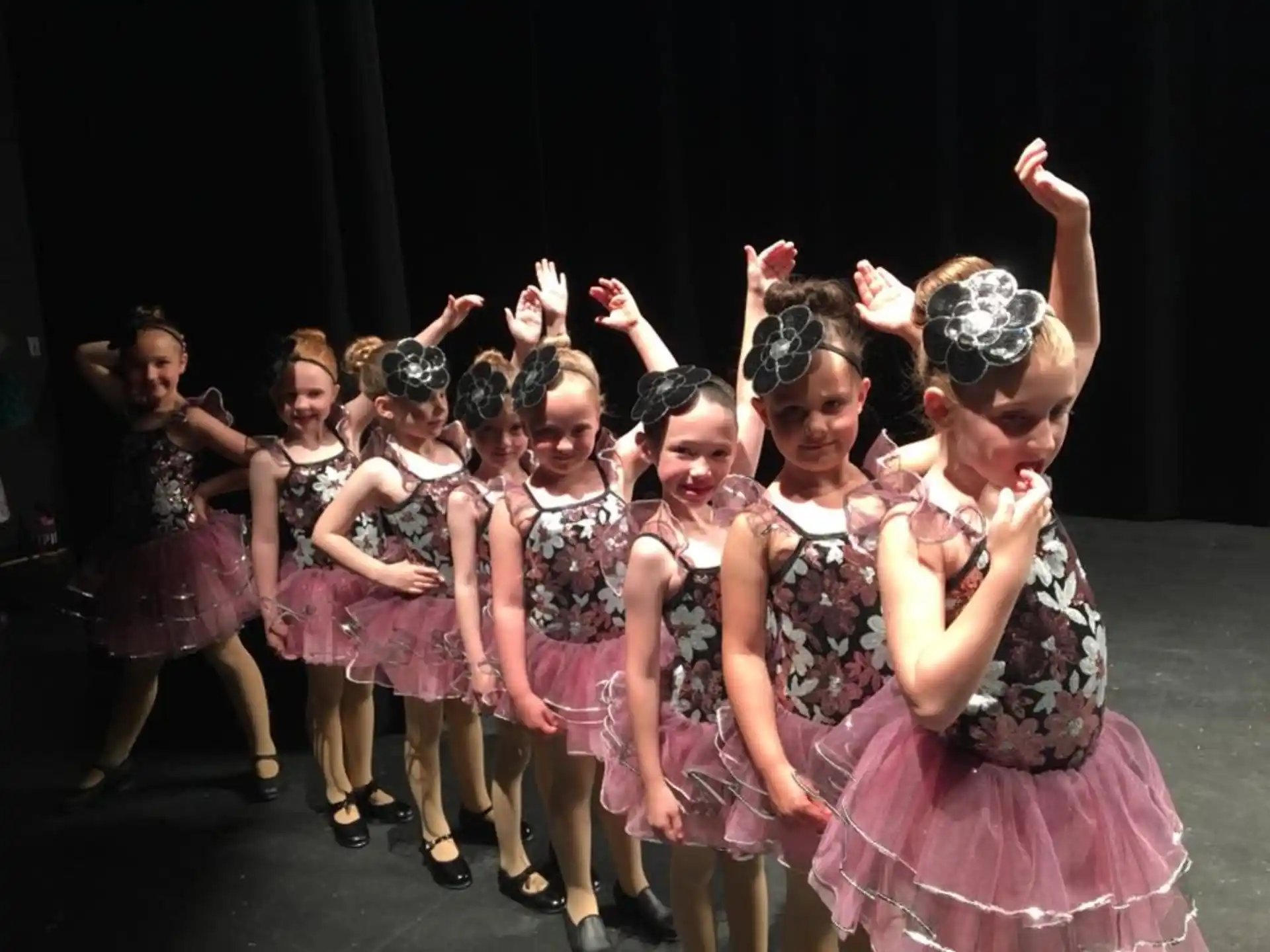 a group of girls in dresses dancing