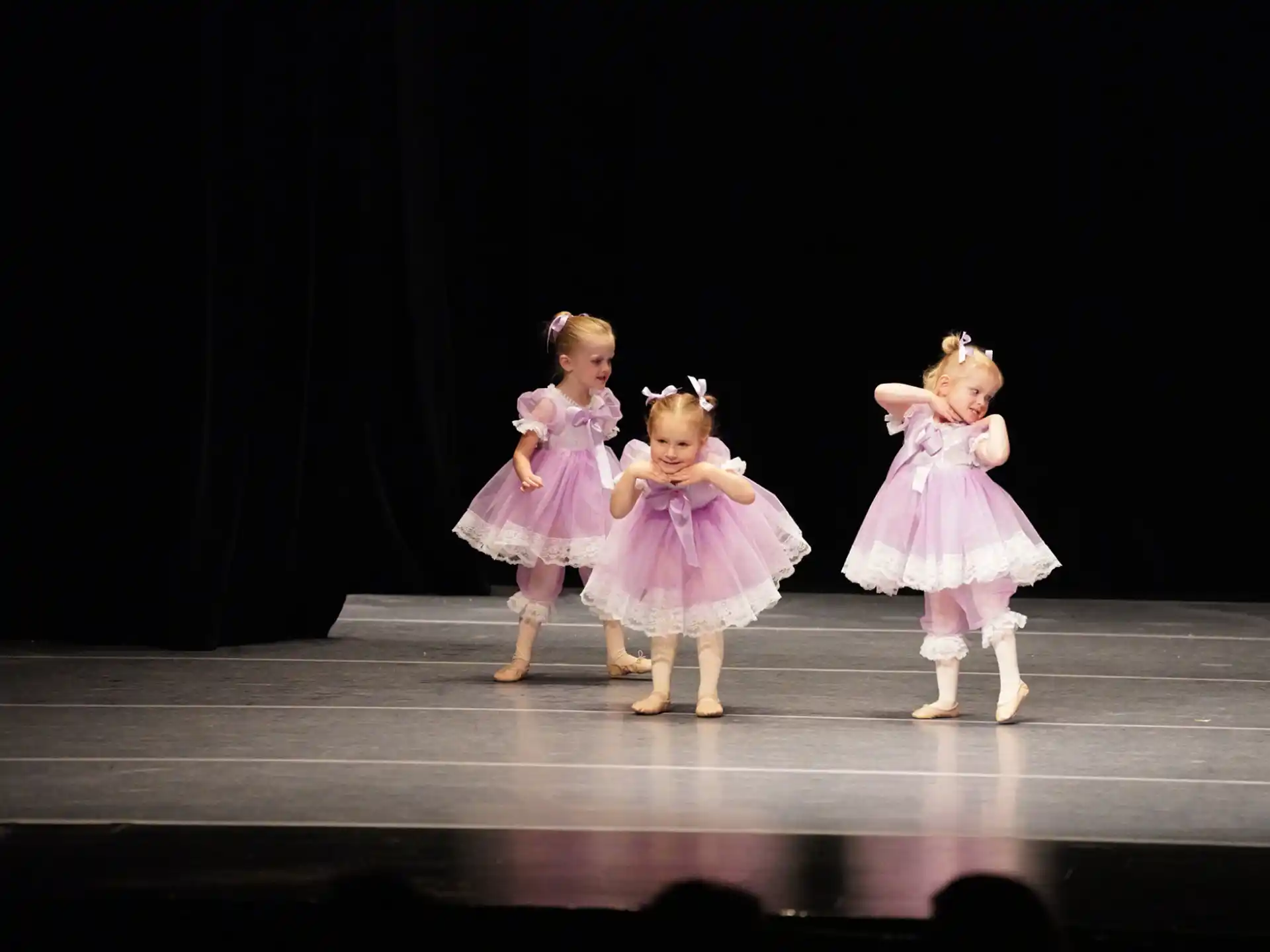 a group of girls in dresses on a stage