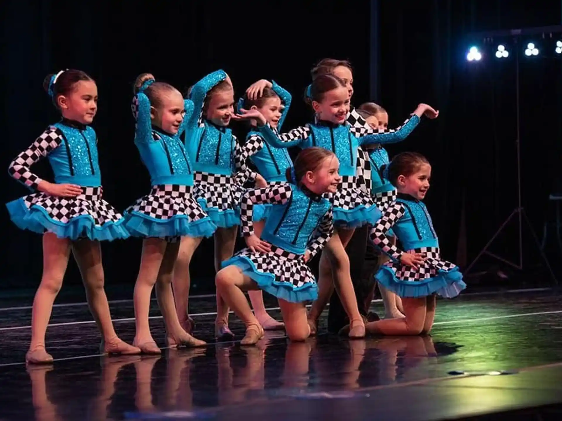 a group of children in blue and white dresses on a stage