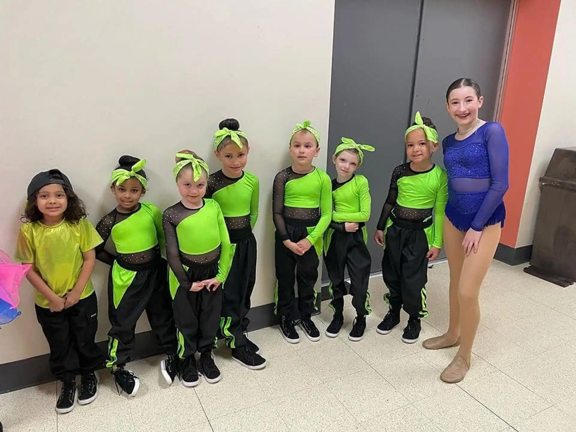 a group of people wearing green and black clothing