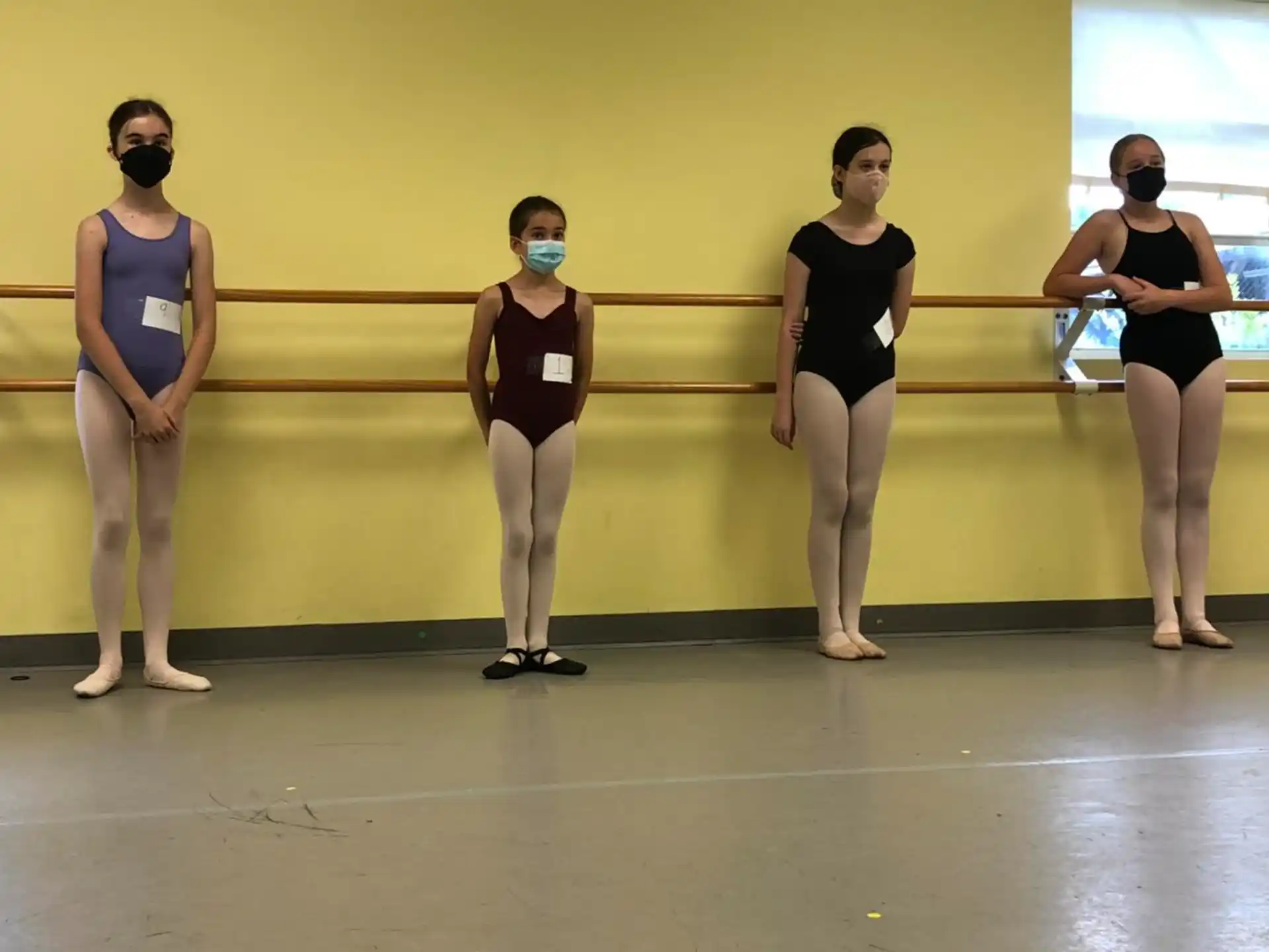 a group of women in leotards standing on a stage