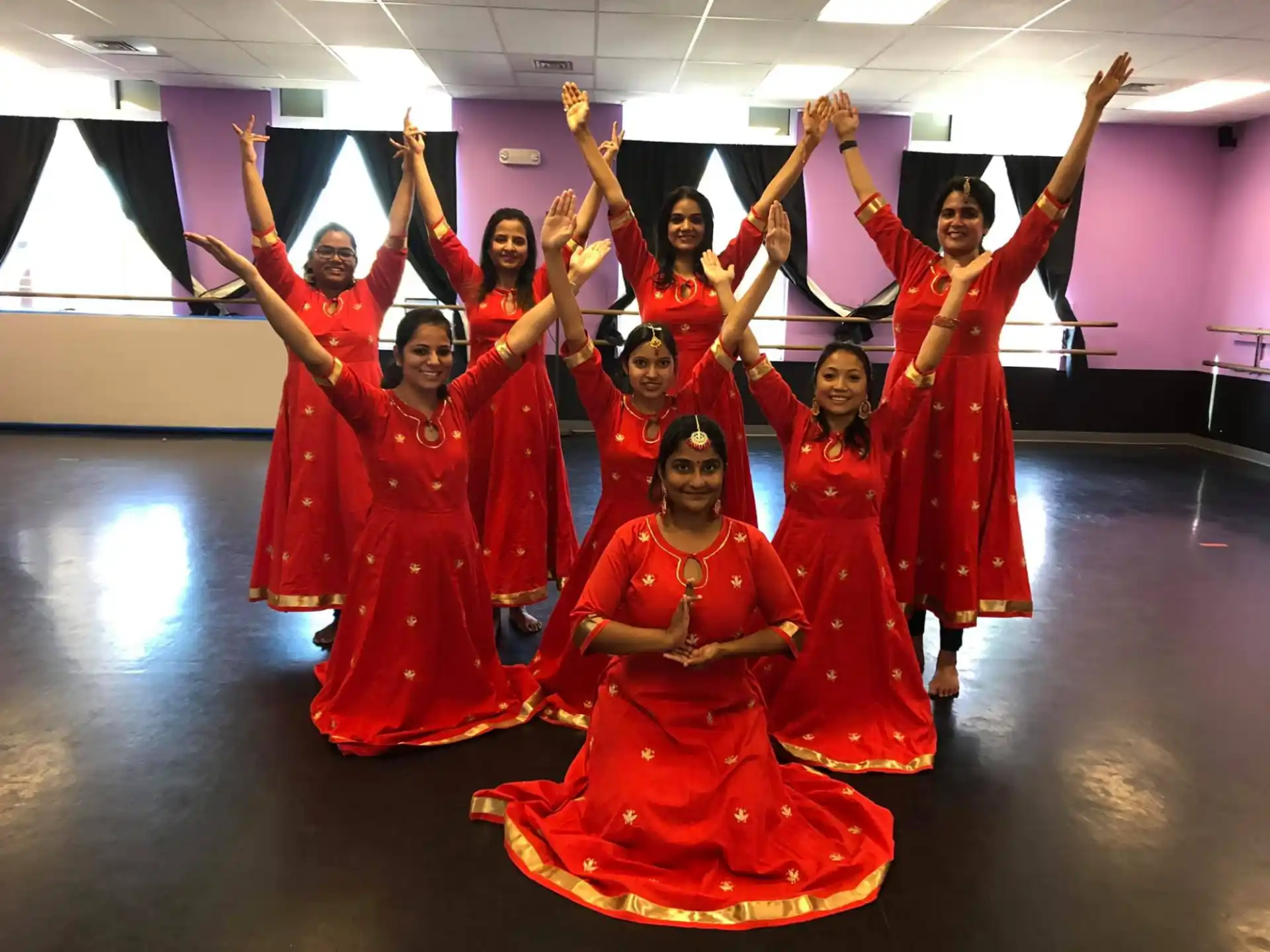 a group of women in red dresses
