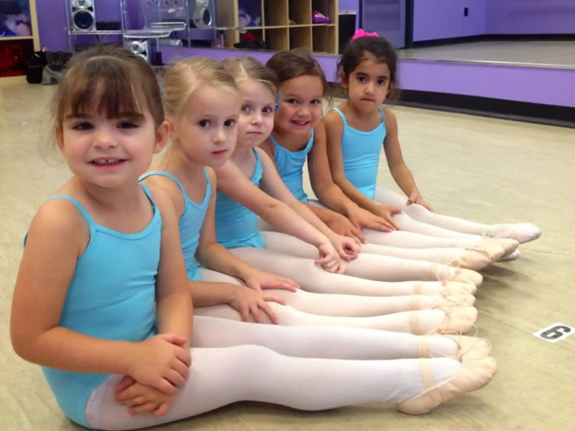 a group of girls sitting on a mat