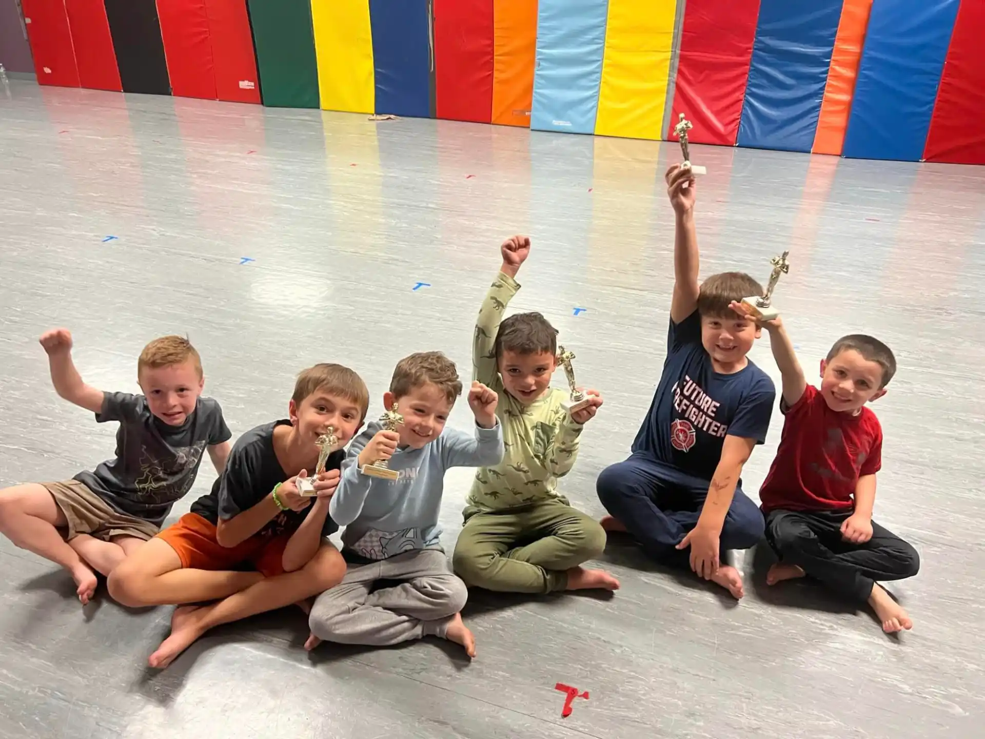 a group of boys sitting on the ground holding food