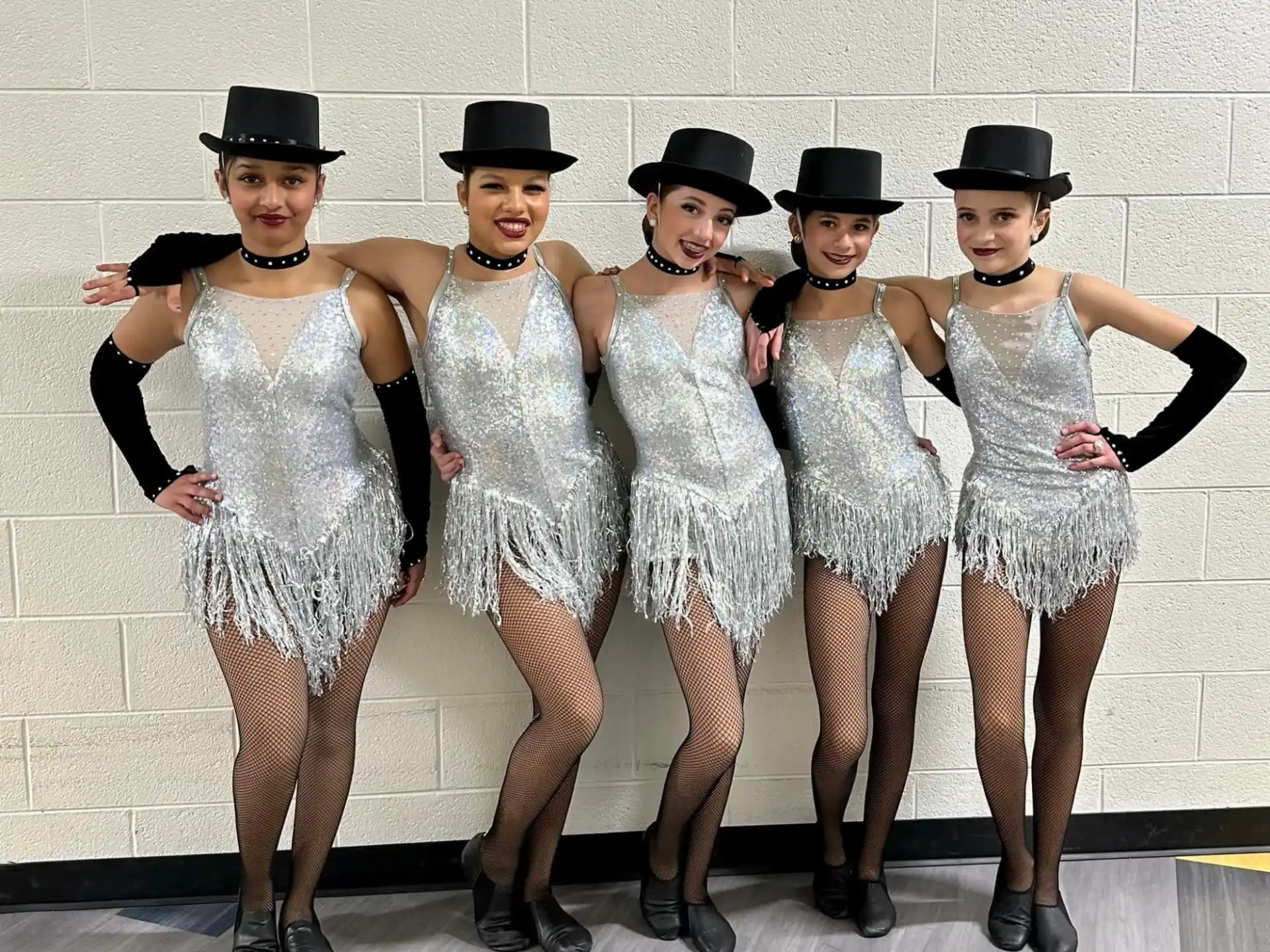 a group of people wearing white and black hats posing for the camera