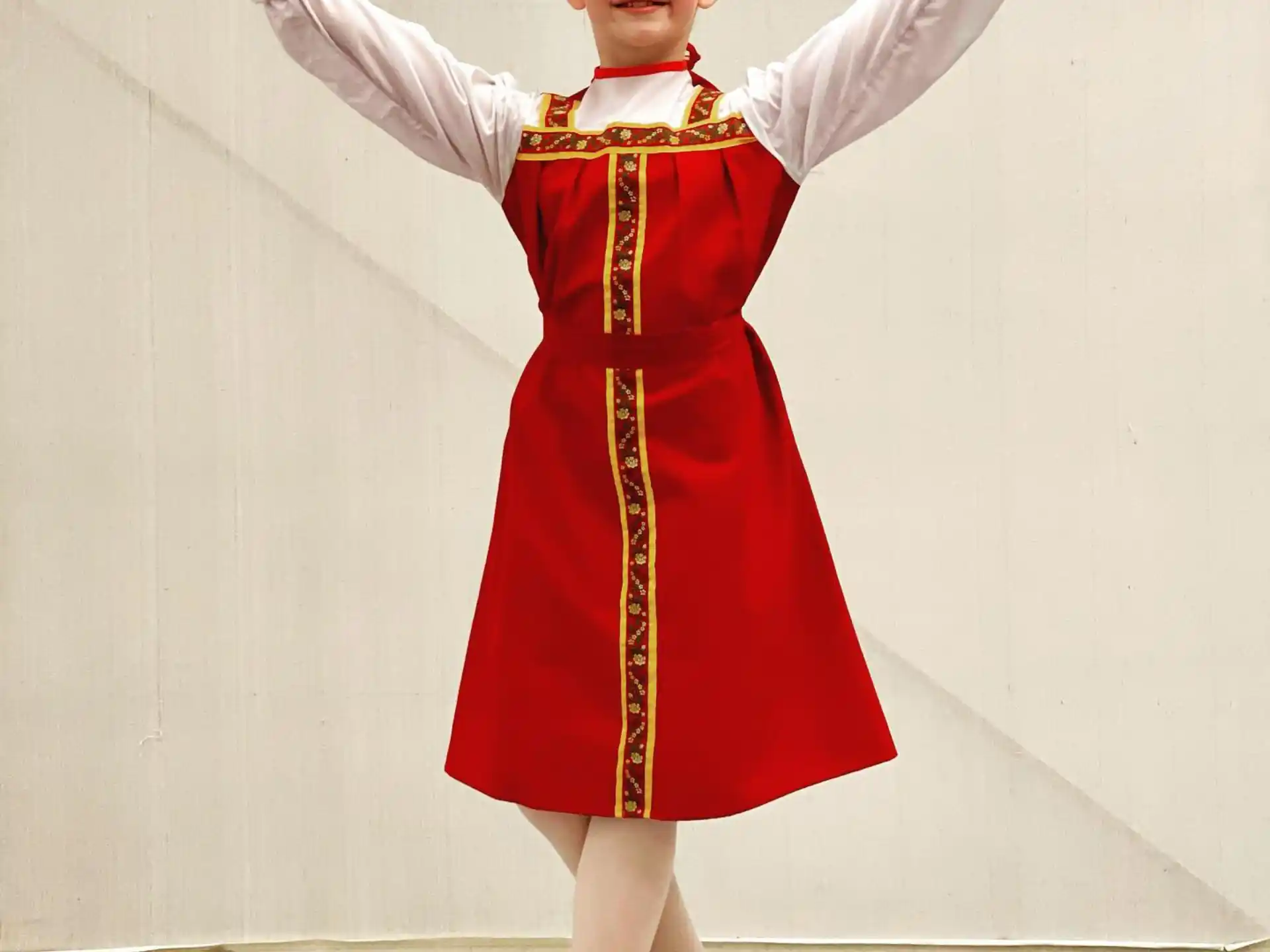 a person in a red dress and gold crown with the arms up