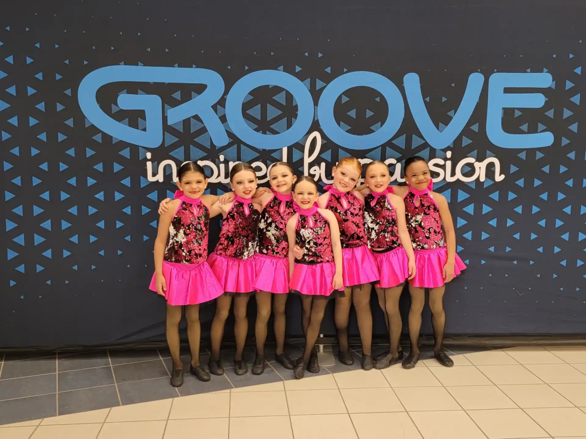 a group of girls in matching outfits