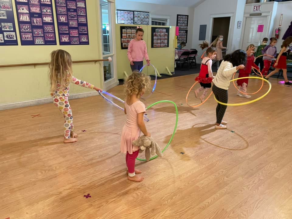a group of children playing with hoops in a room