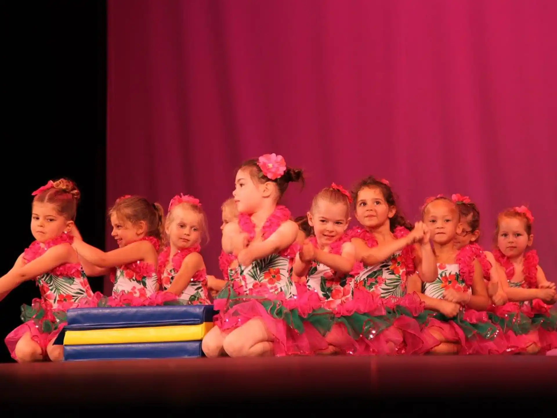 a group of girls in dresses on a stage
