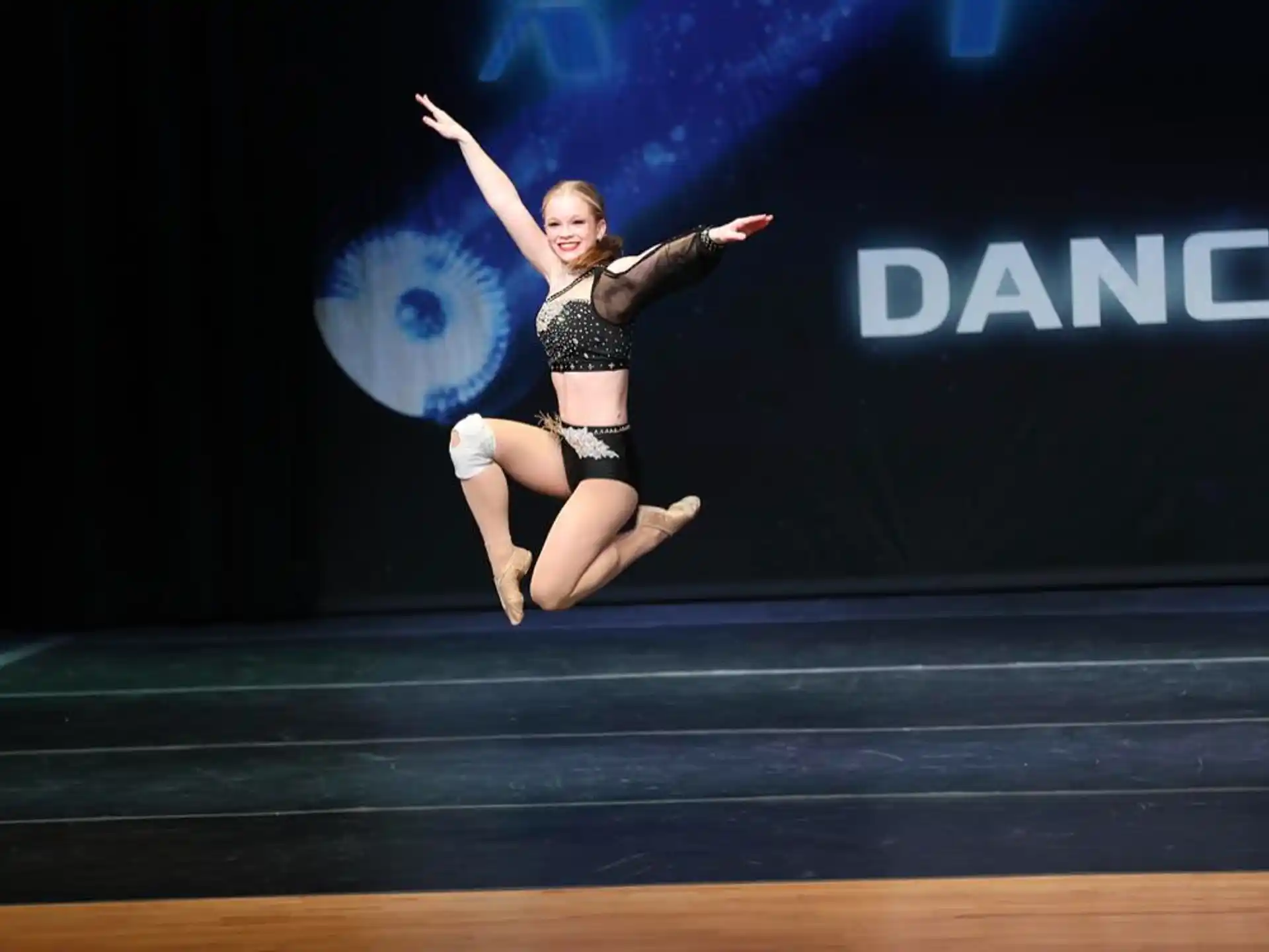 a woman jumping on a stage