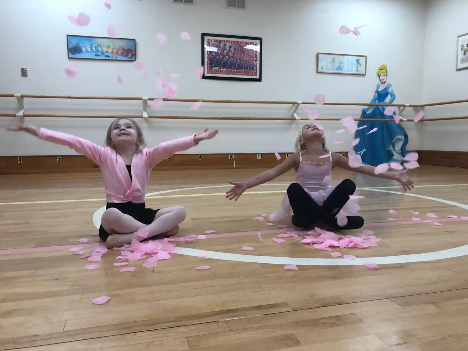 a group of girls in clothing on a wood floor