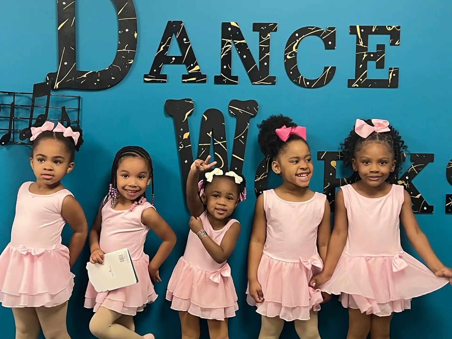 a group of girls in pink dresses