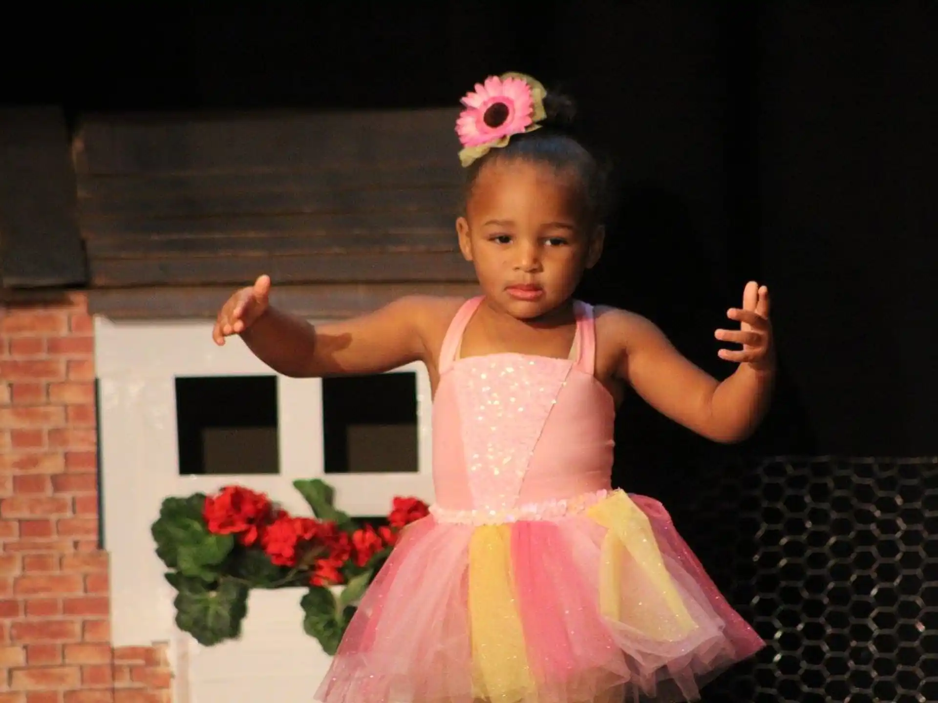 a little girl wearing a pink dress and holding flowers