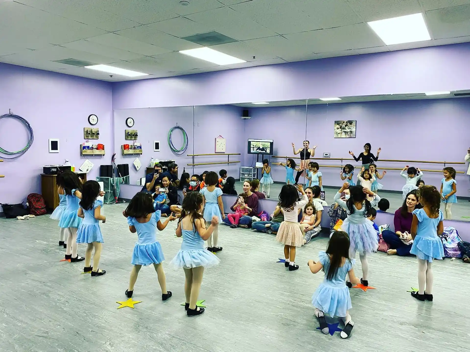a group of children dancing in a room with purple walls