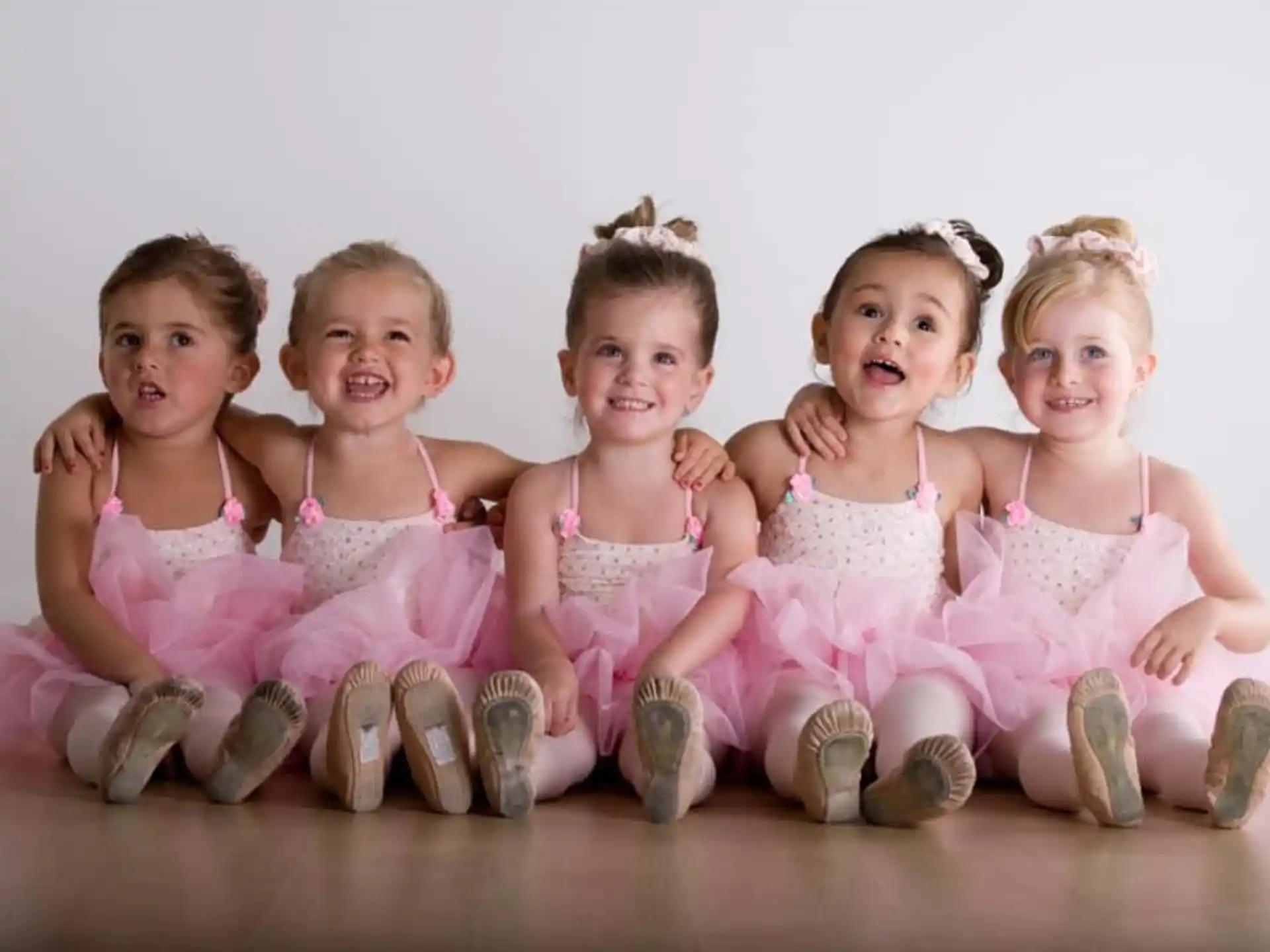 a group of children in pink dresses