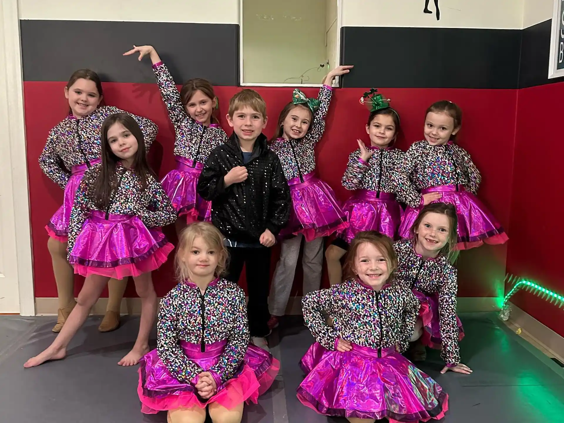 a group of girls in dresses and skirts posing for a photo