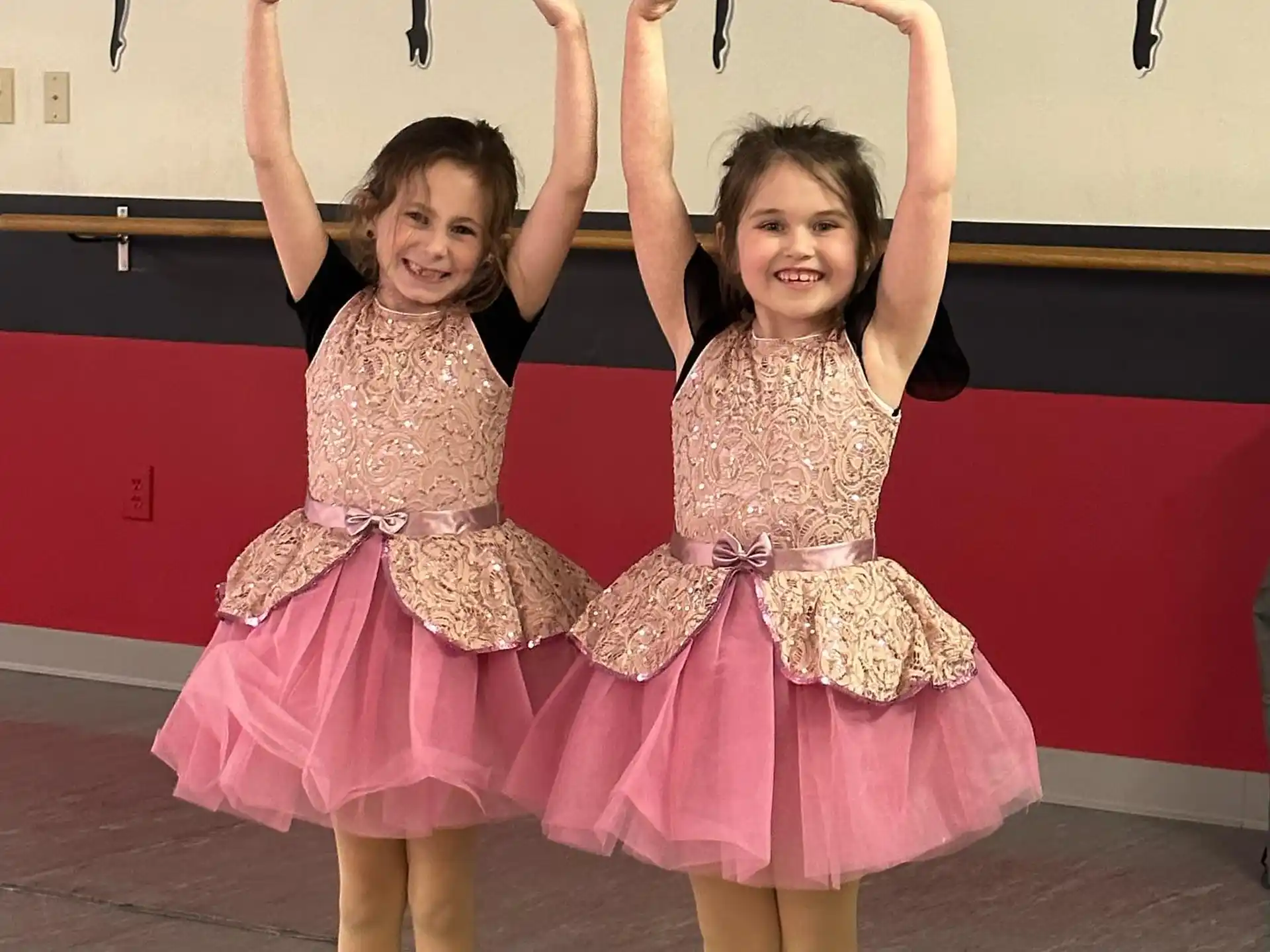 two girls wearing dresses and posing for a picture