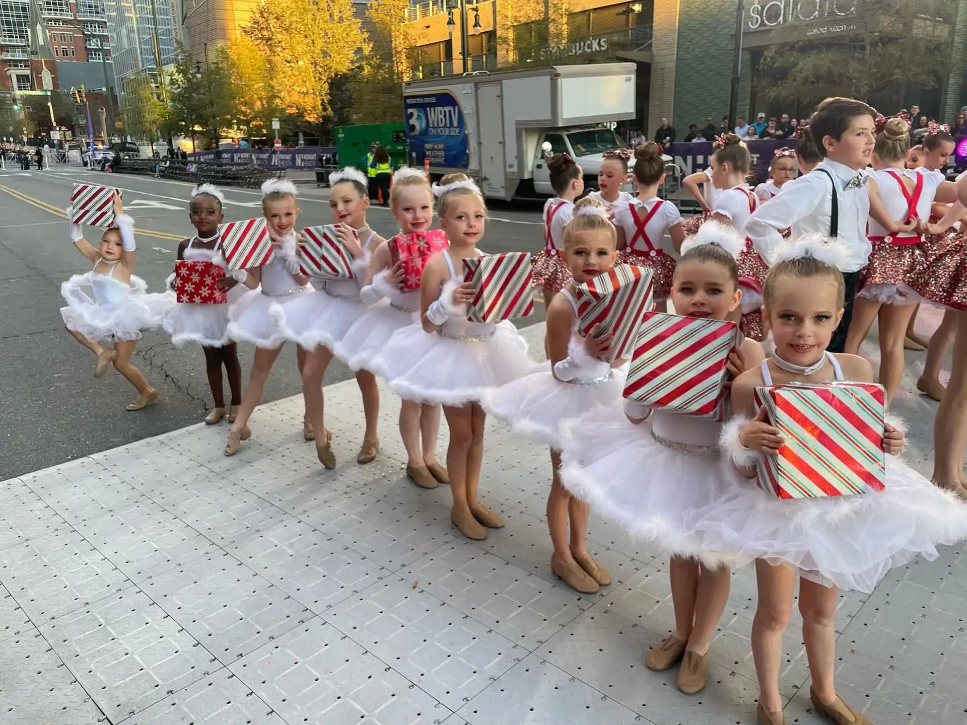 a group of children in white and red dresses dancing