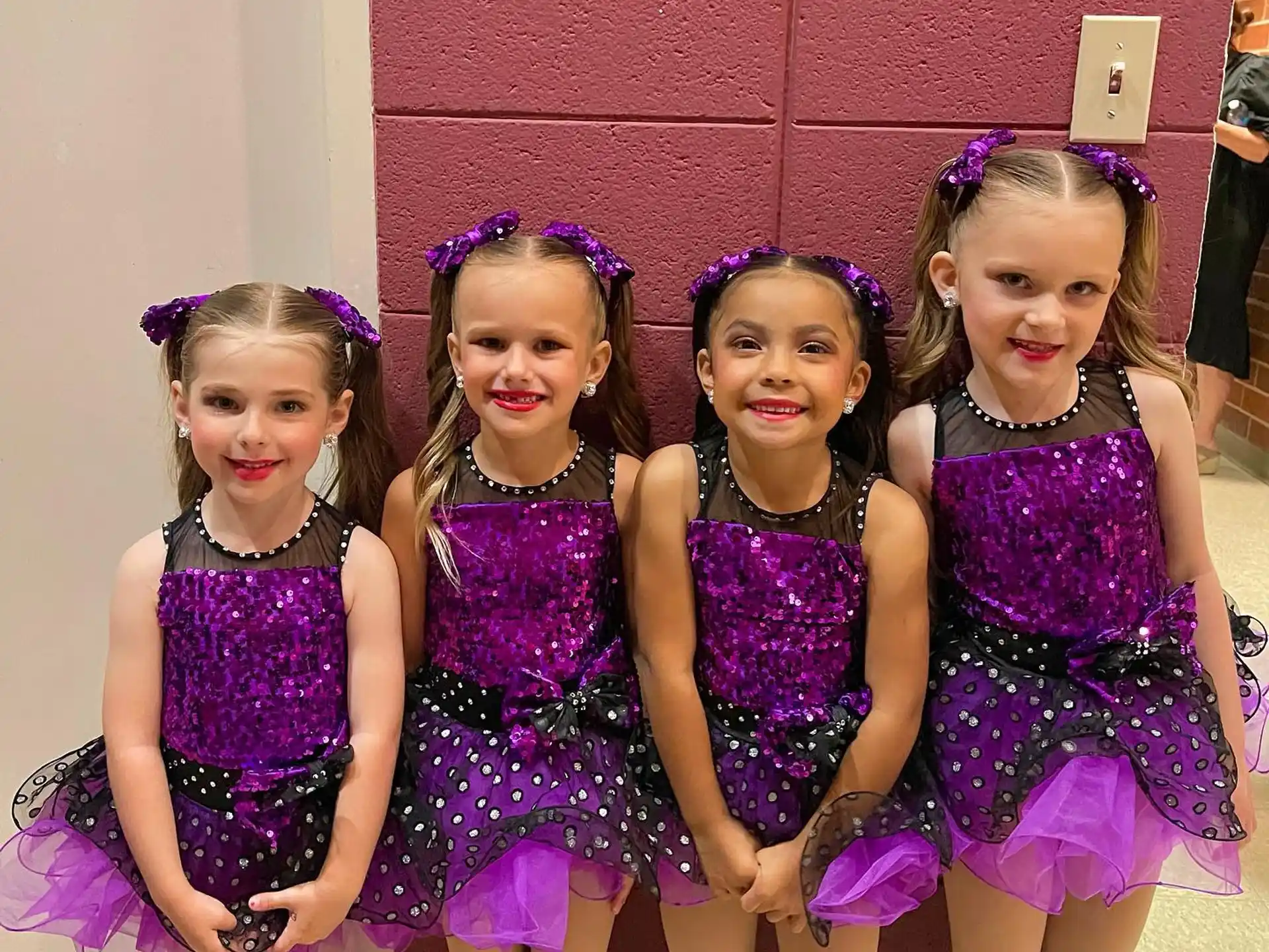 a group of girls in purple dresses