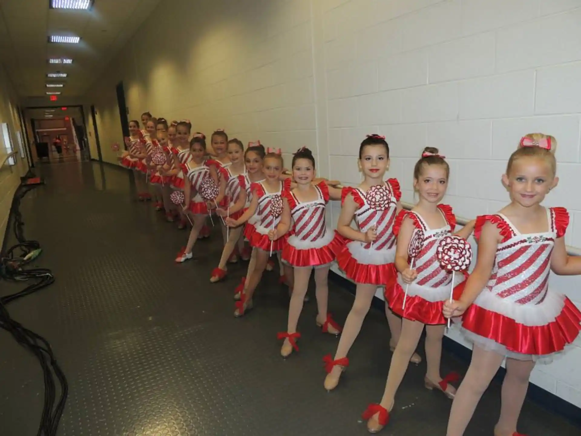 a group of girls in red and white dresses in a room