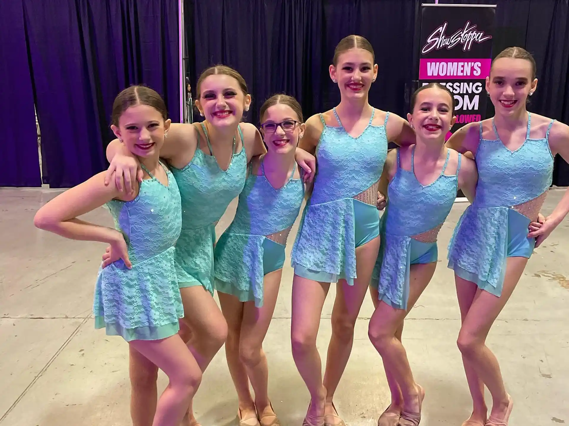 a group of women in blue dresses