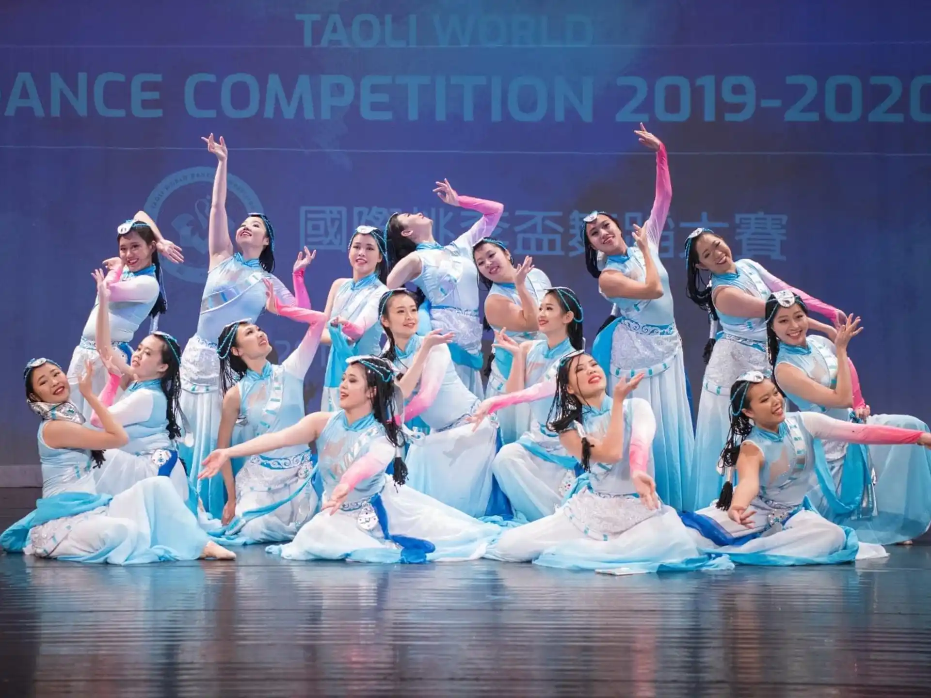 a group of women in white dresses on a stage