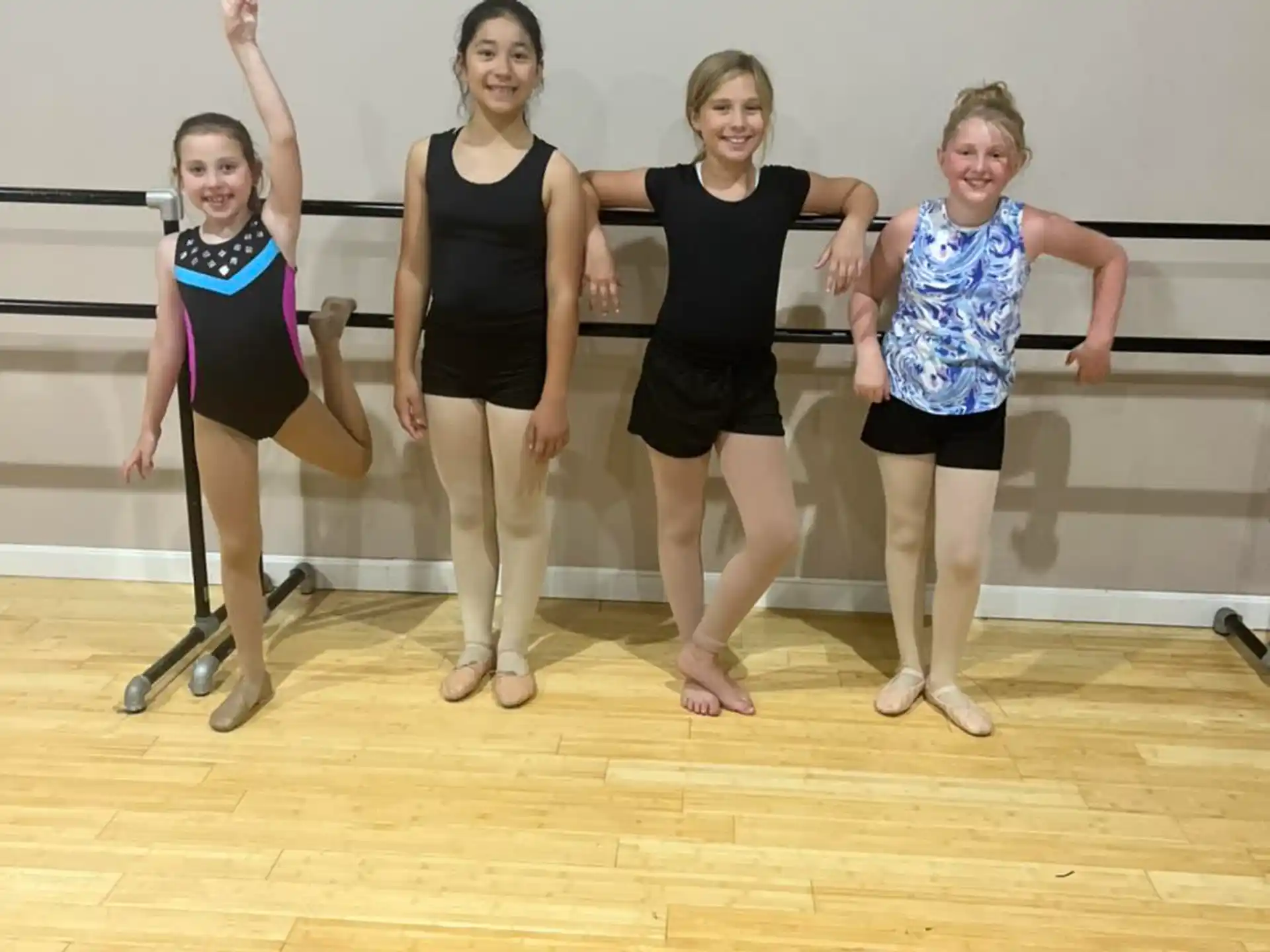 a group of women in leotards posing for a photo