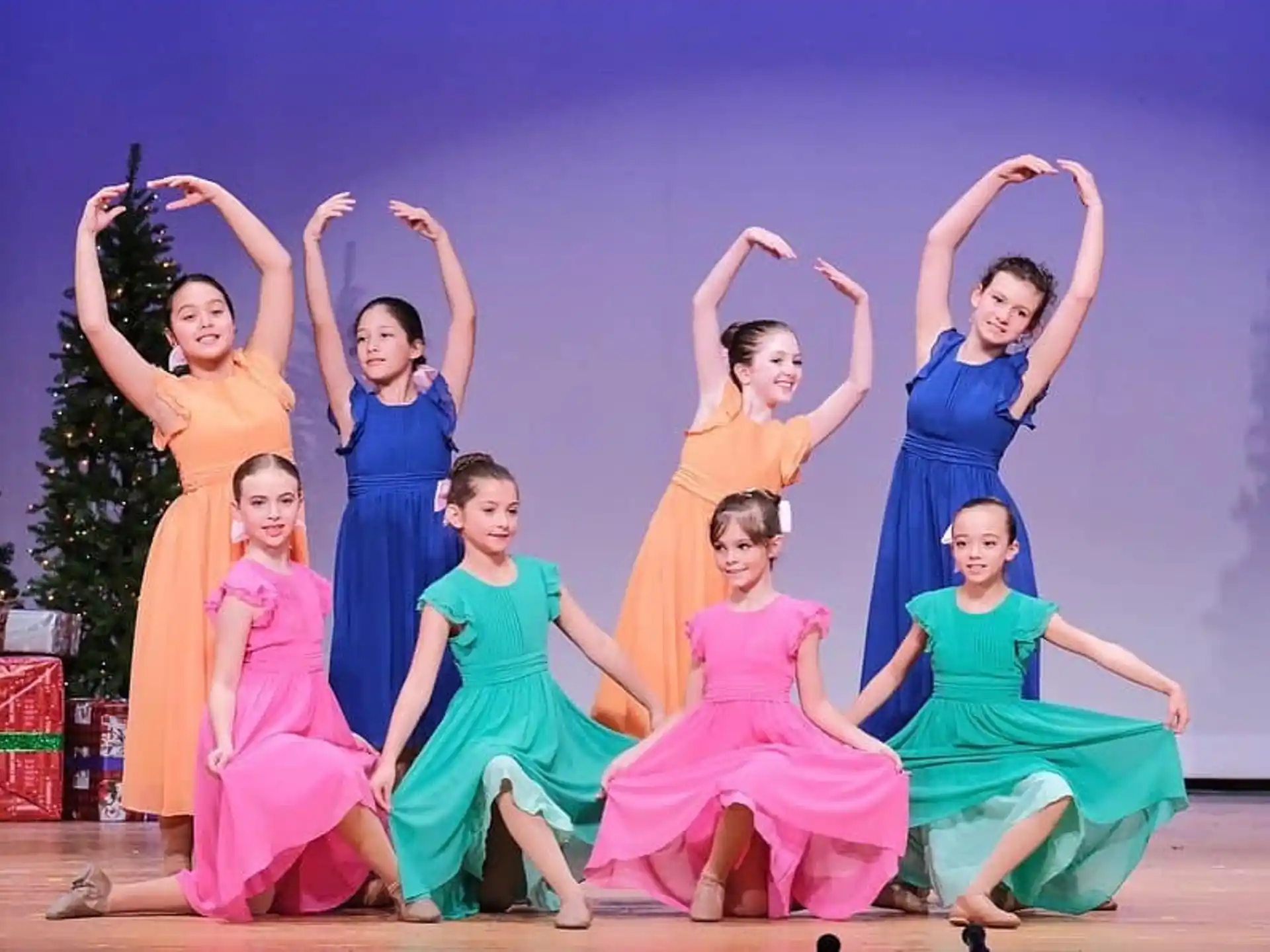 a group of women in dresses posing for a photo