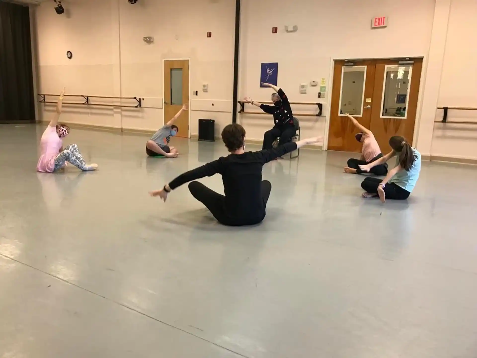a group of people kneeling on the floor in a room with a wood floor and a wood door