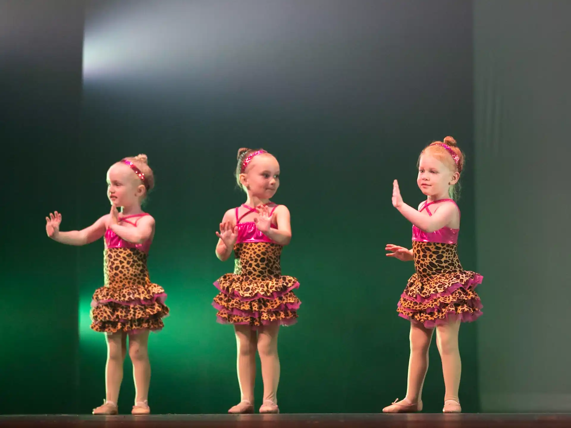 a group of girls in dresses on a stage
