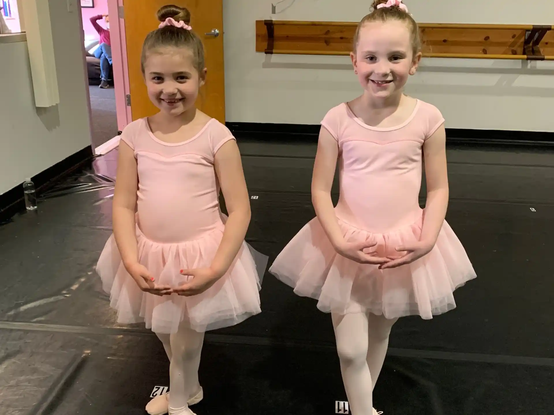 two girls wearing dresses and posing for a picture