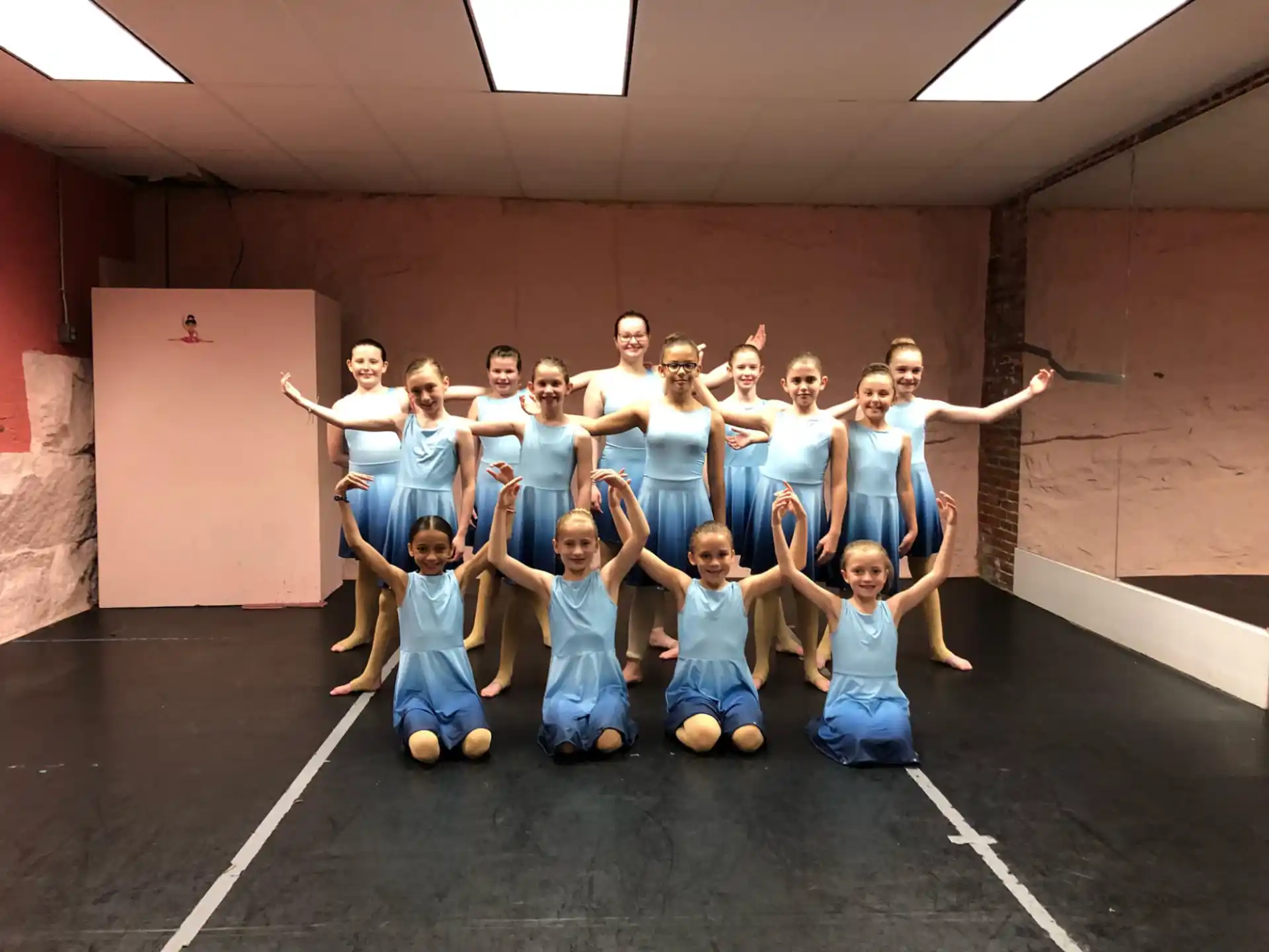 a group of girls in blue dresses posing for a photo