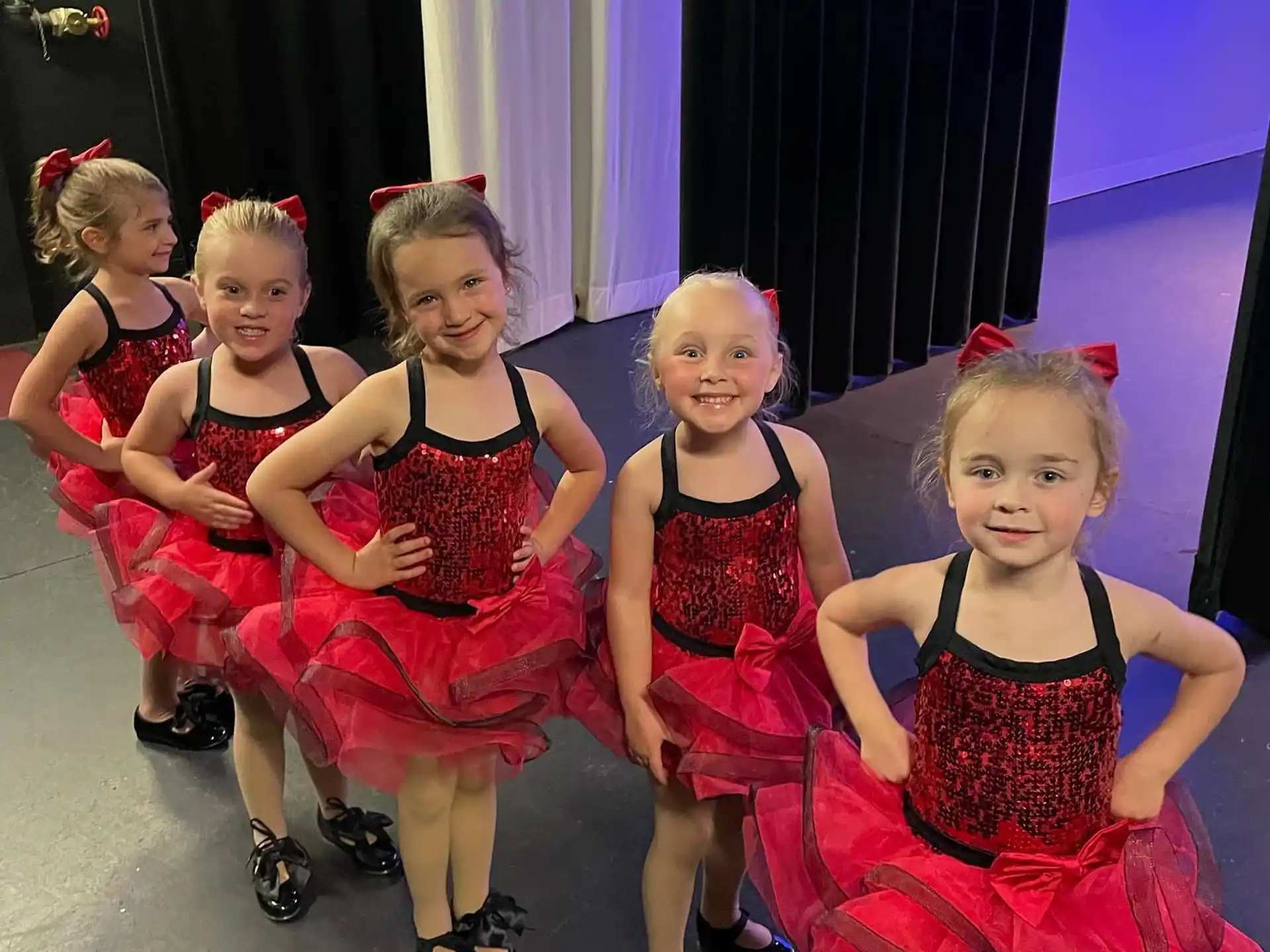 a group of girls in red dresses