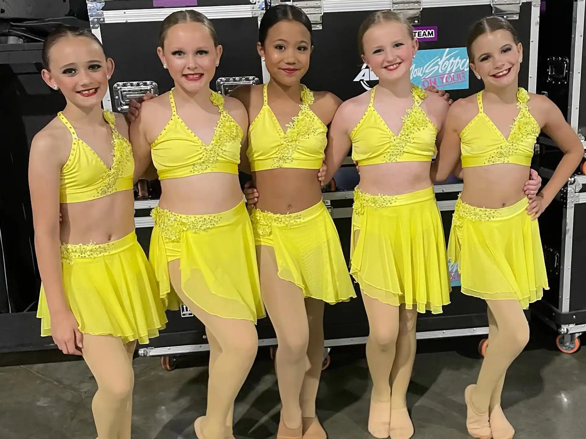 a group of women in yellow dresses