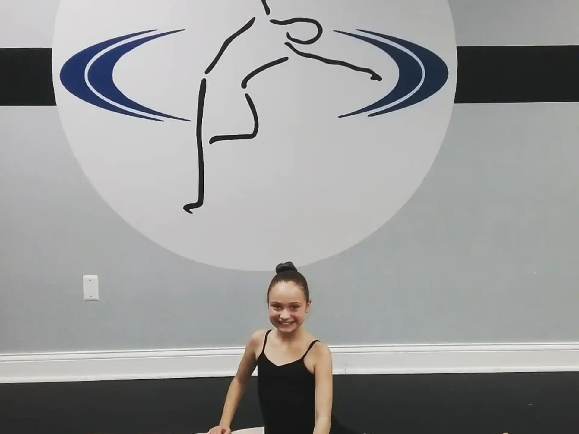 a person posing in front of a logo