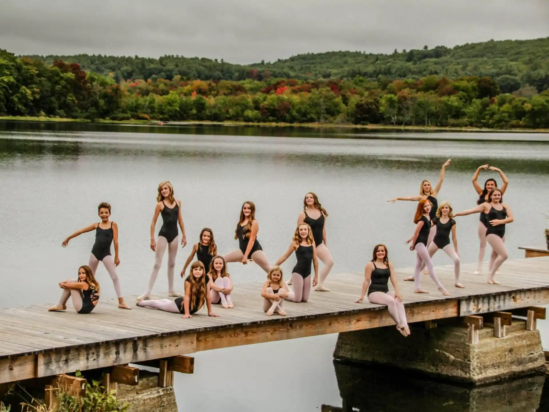 a group of women posing on a dock over water