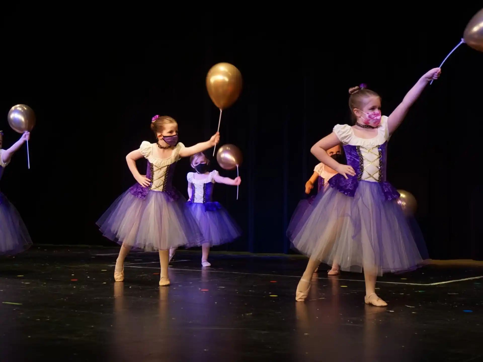 a group of women in dresses holding balloons