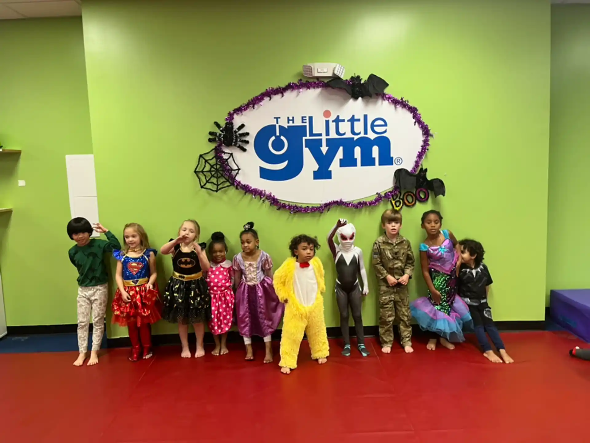 a group of children posing for a photo in front of a sign
